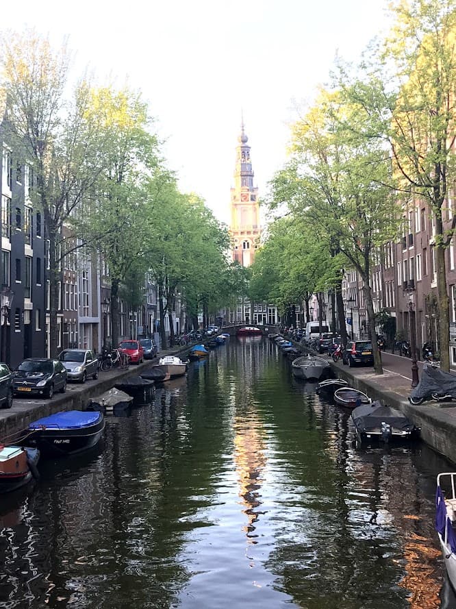 A scenic canal featuring boats with buildings lining the background, showcasing a picturesque urban landscape.