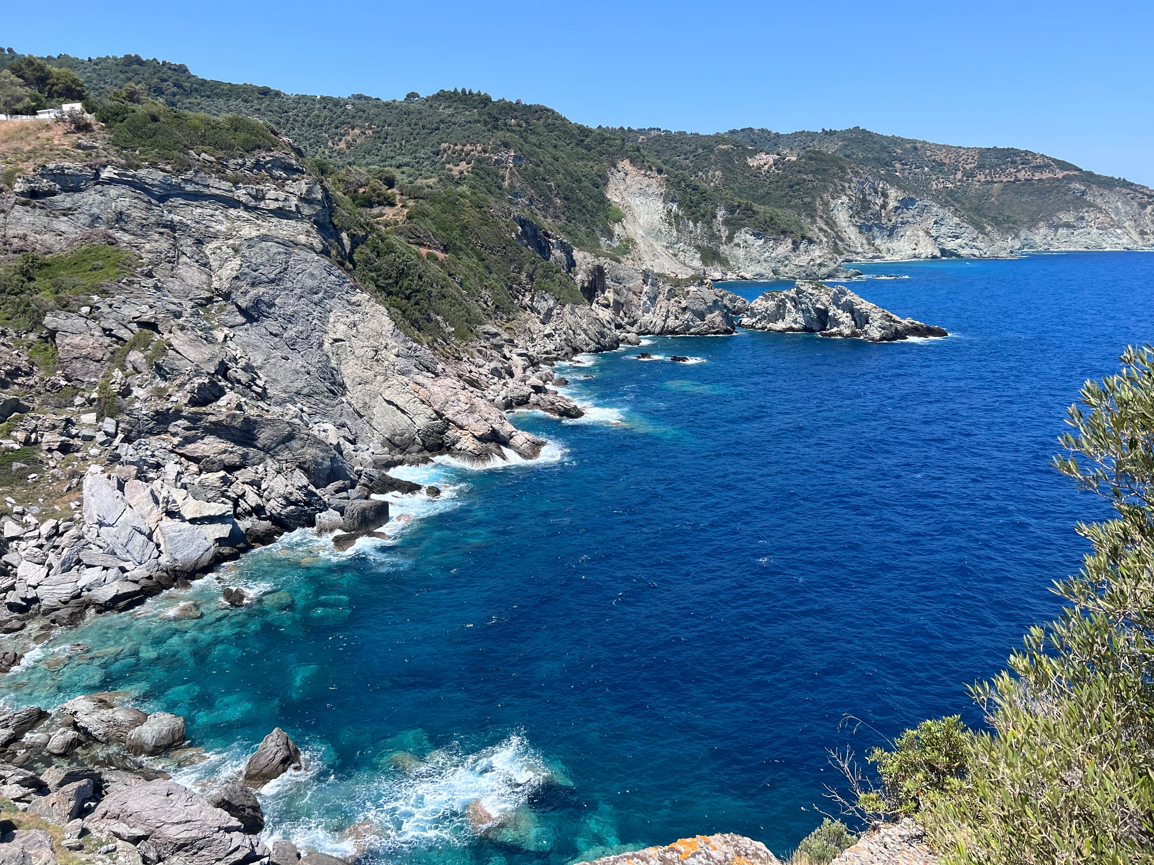 A picturesque view of lush green hills under a bright sky, and a tranquil lake reflecting the surrounding nature.