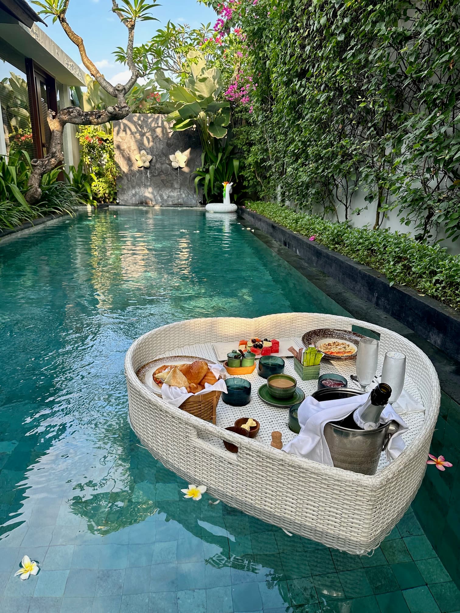 View of a floating breakfast spread in a private plunge pool surrounded by plants