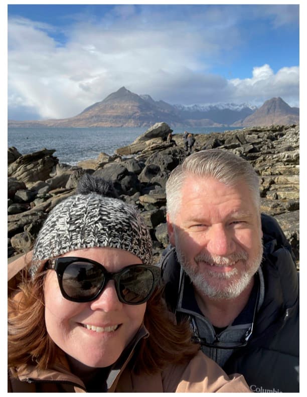 Advisor and partner taking a selfie on a hike in the mountains with the sea in the distance