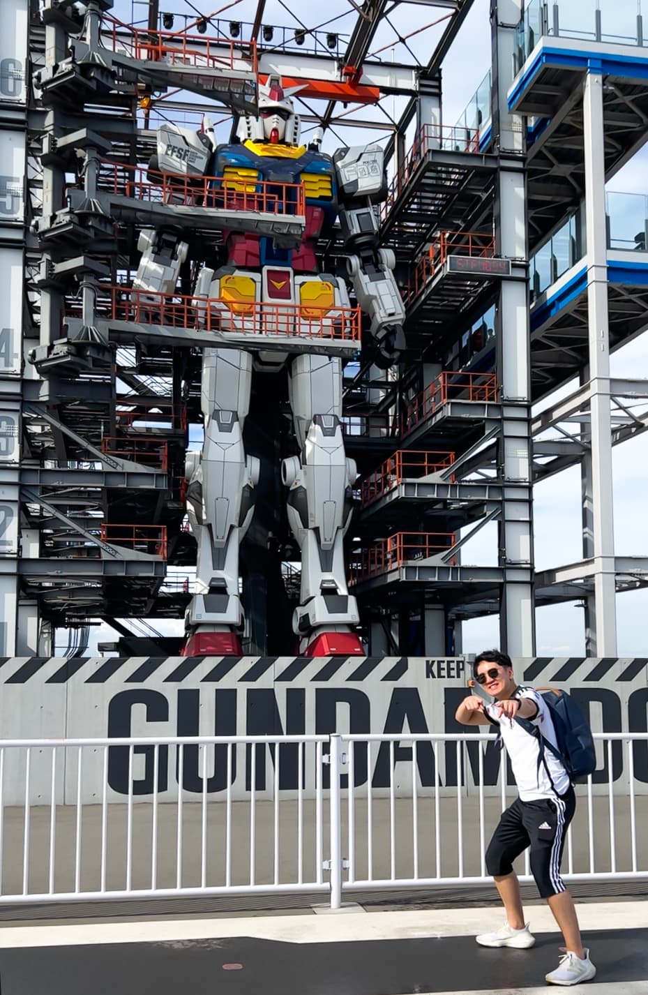 Advisor posing in front of a life-sized Transformer robot during the day