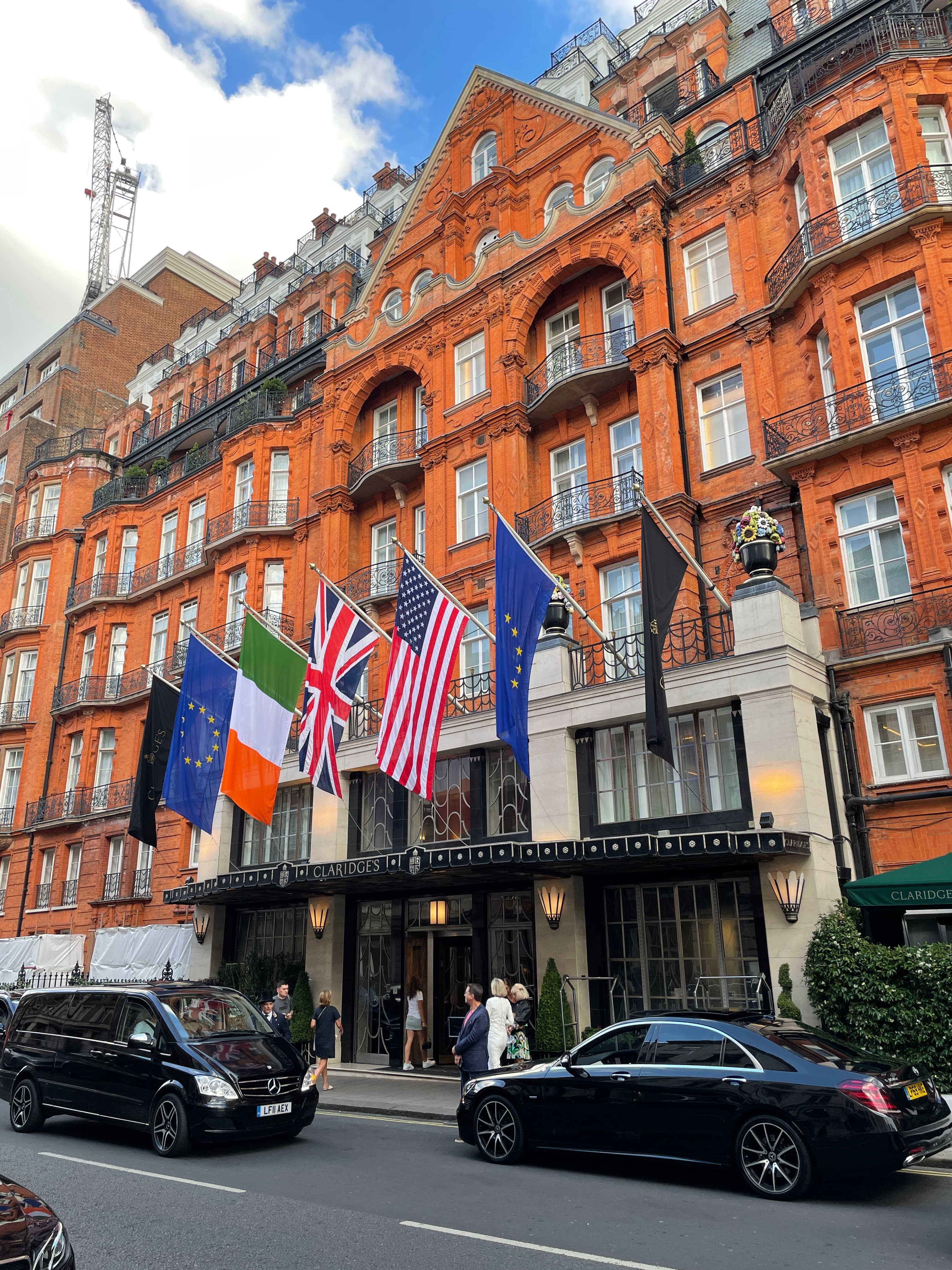View of various national flags hanging outside the front of Claridge’s in London on a sunny day