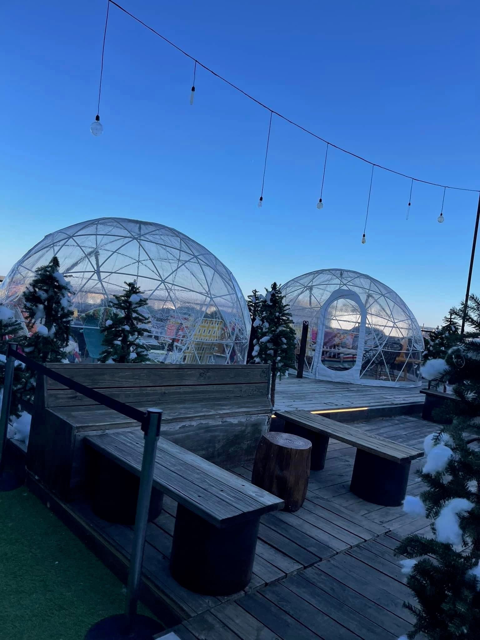 View of plastic igloo structures on a rooftop under clear skies