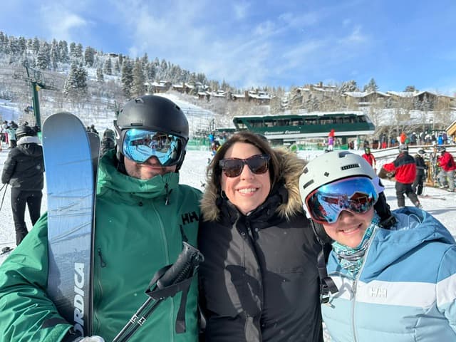 Jessica and family posing in the snow while skiing.