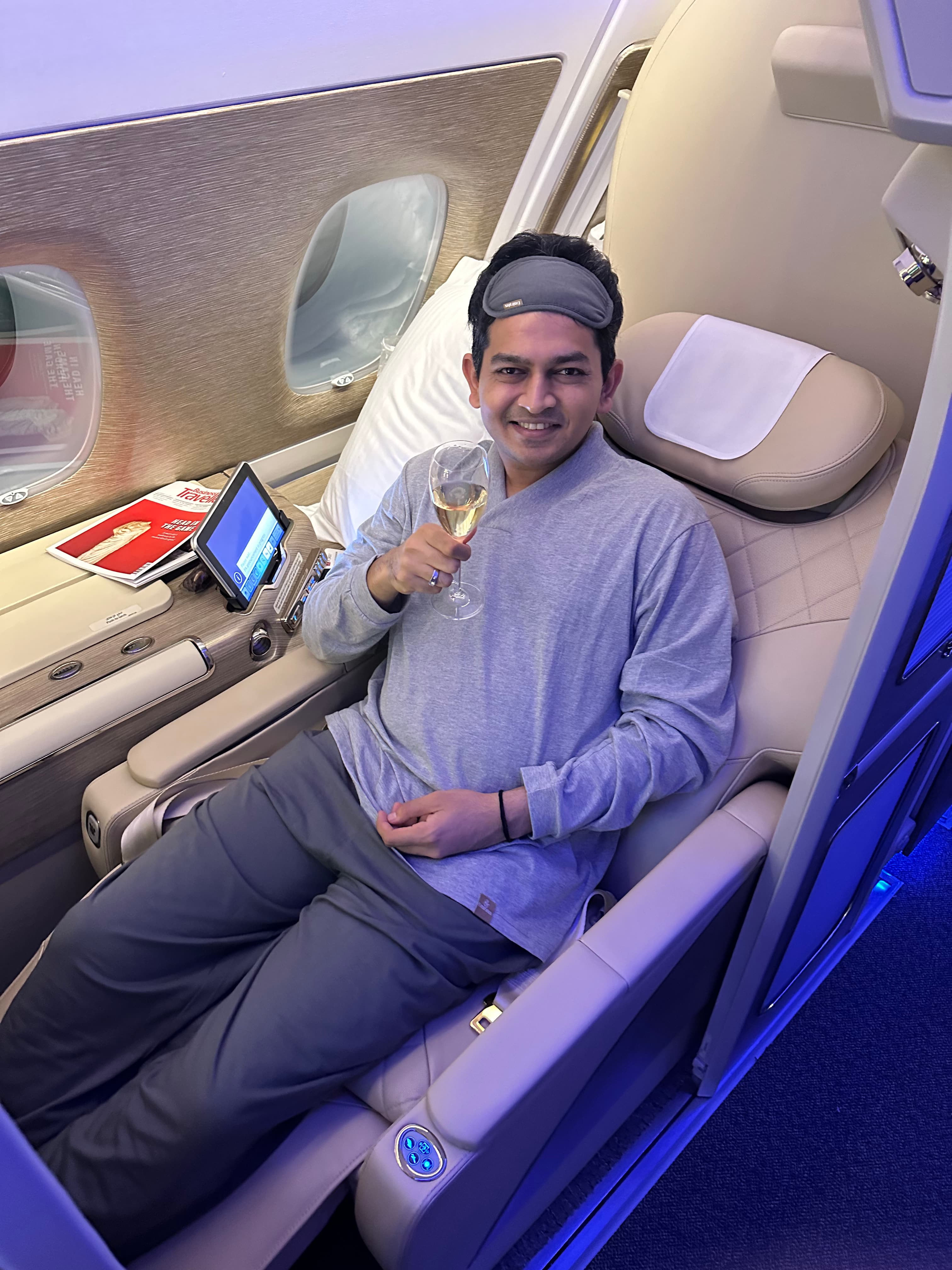 Advisor sitting in a first class airline cabin with sleeping mask on his forehead