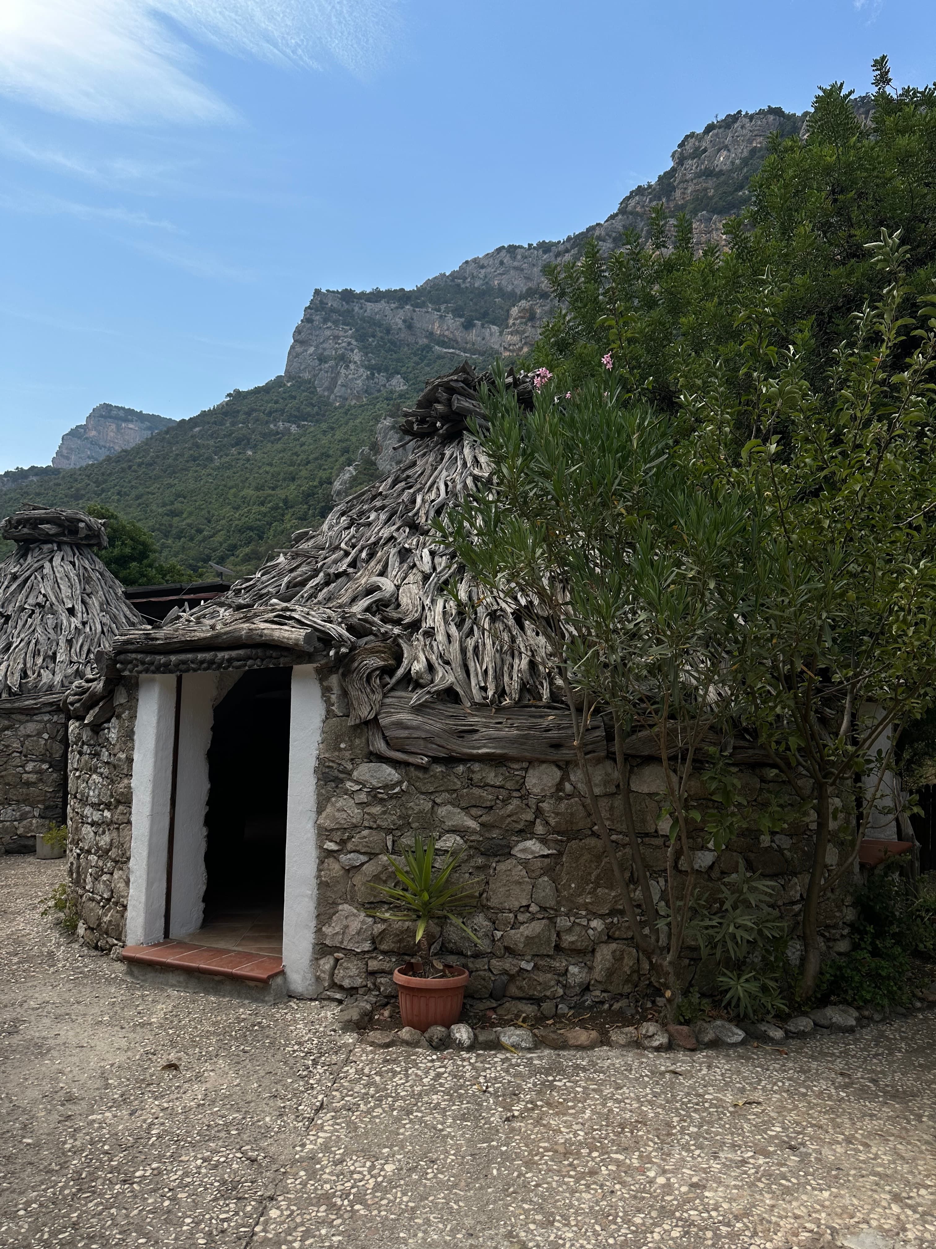View of a doorway leading into a circular stone hut in the mountains