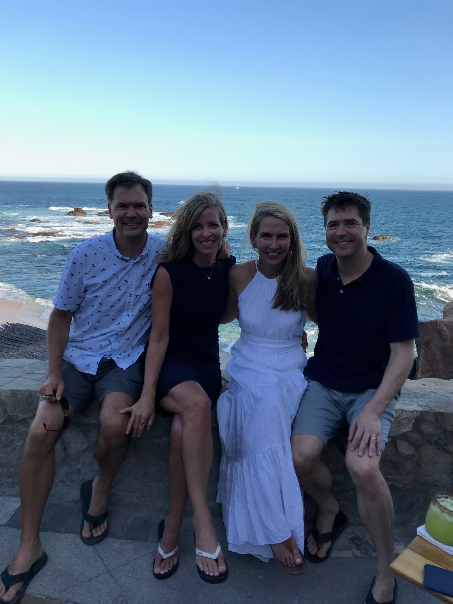 Advisor and family sitting side by side on a sunny day at the beach