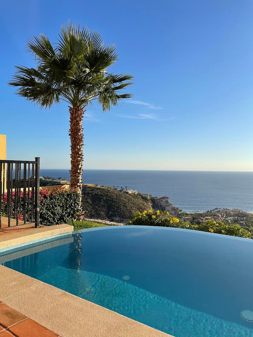 View of a small infinity pool overlooking a beautiful coastline at sunset