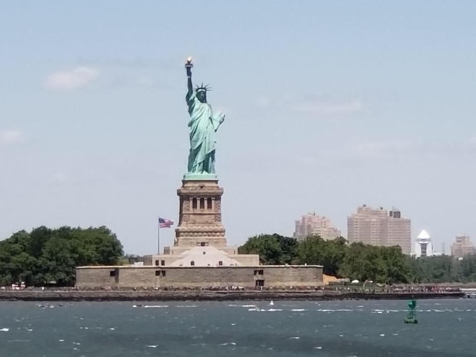 The Statue of Liberty seen from a passing boat on a sunny day