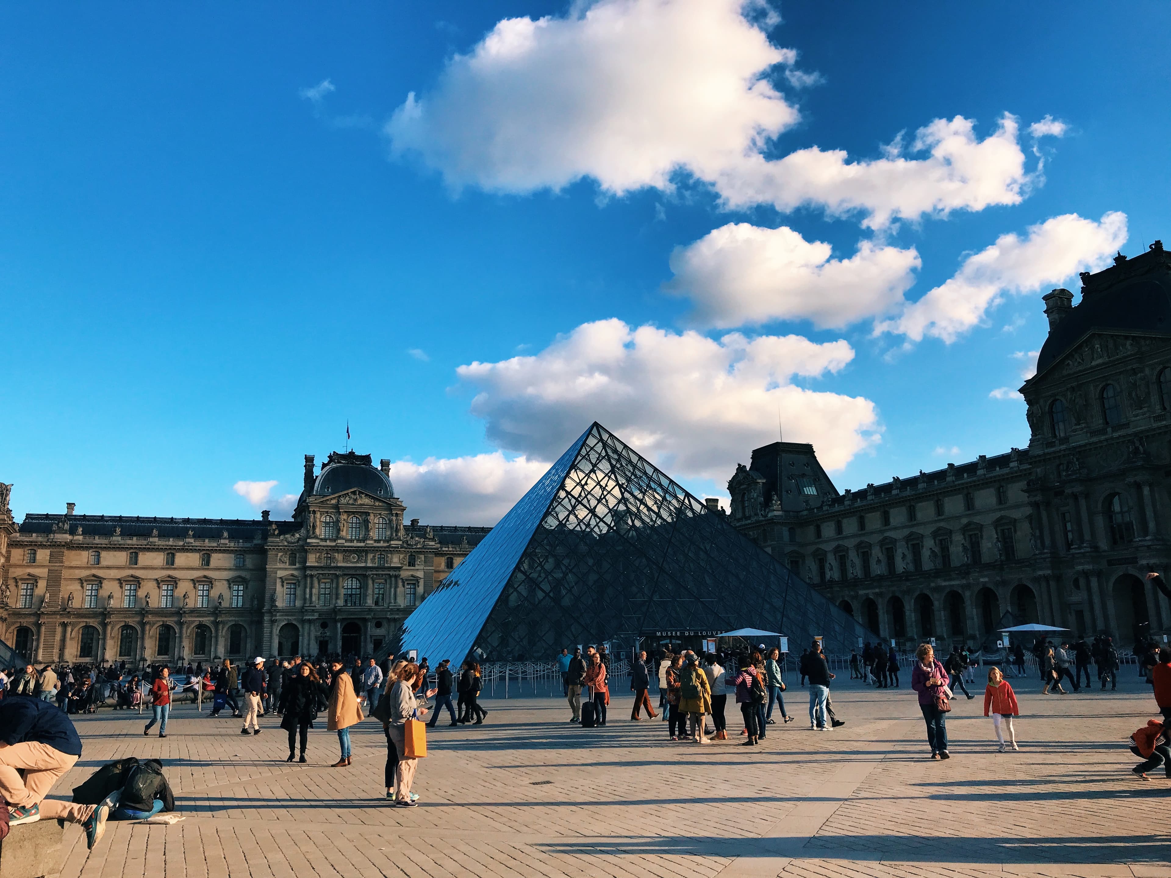 A view of the Louvre Museum on a sunny day in Paris.