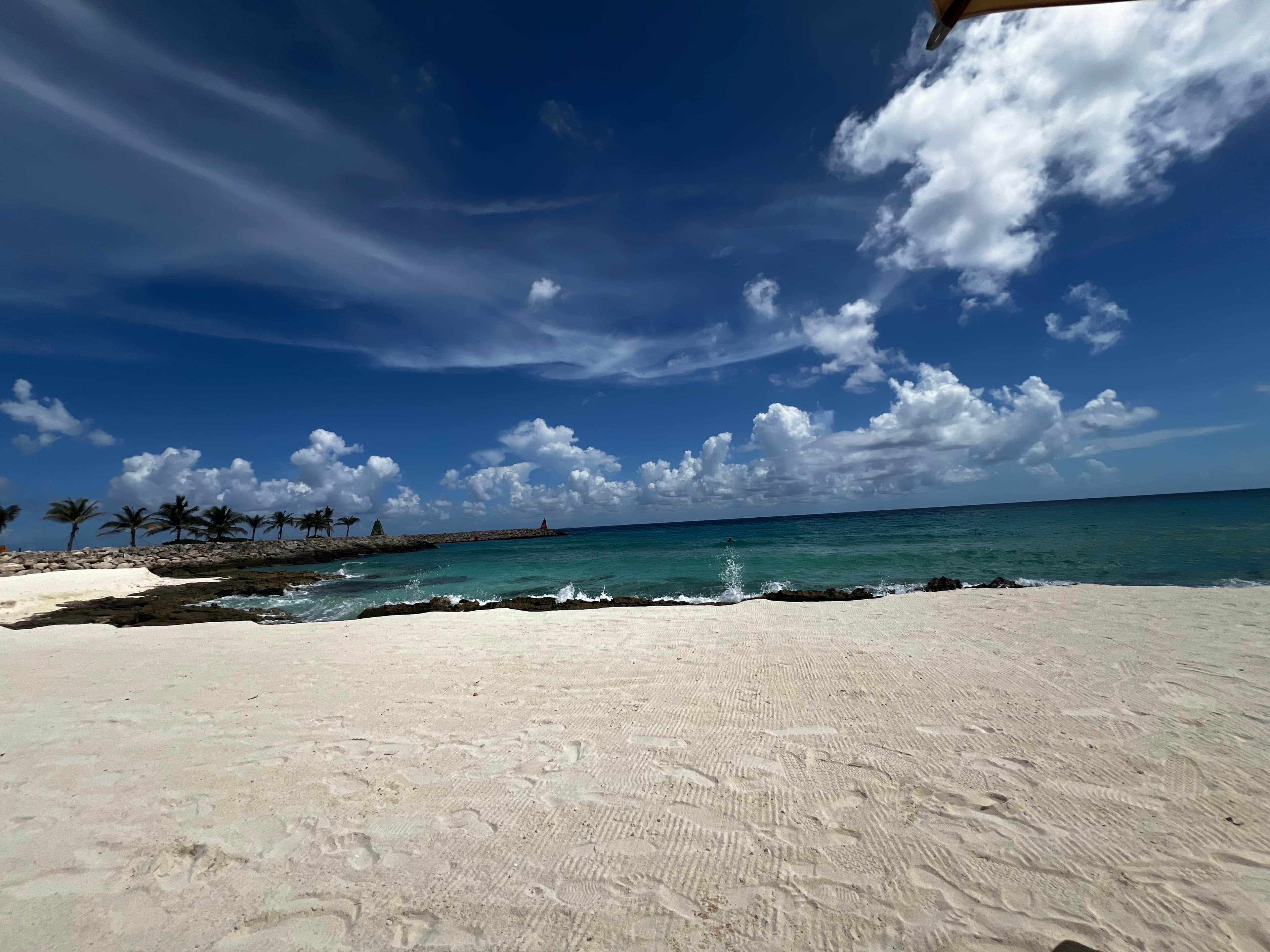 View of a white sandy beach and ocean on a sunny day