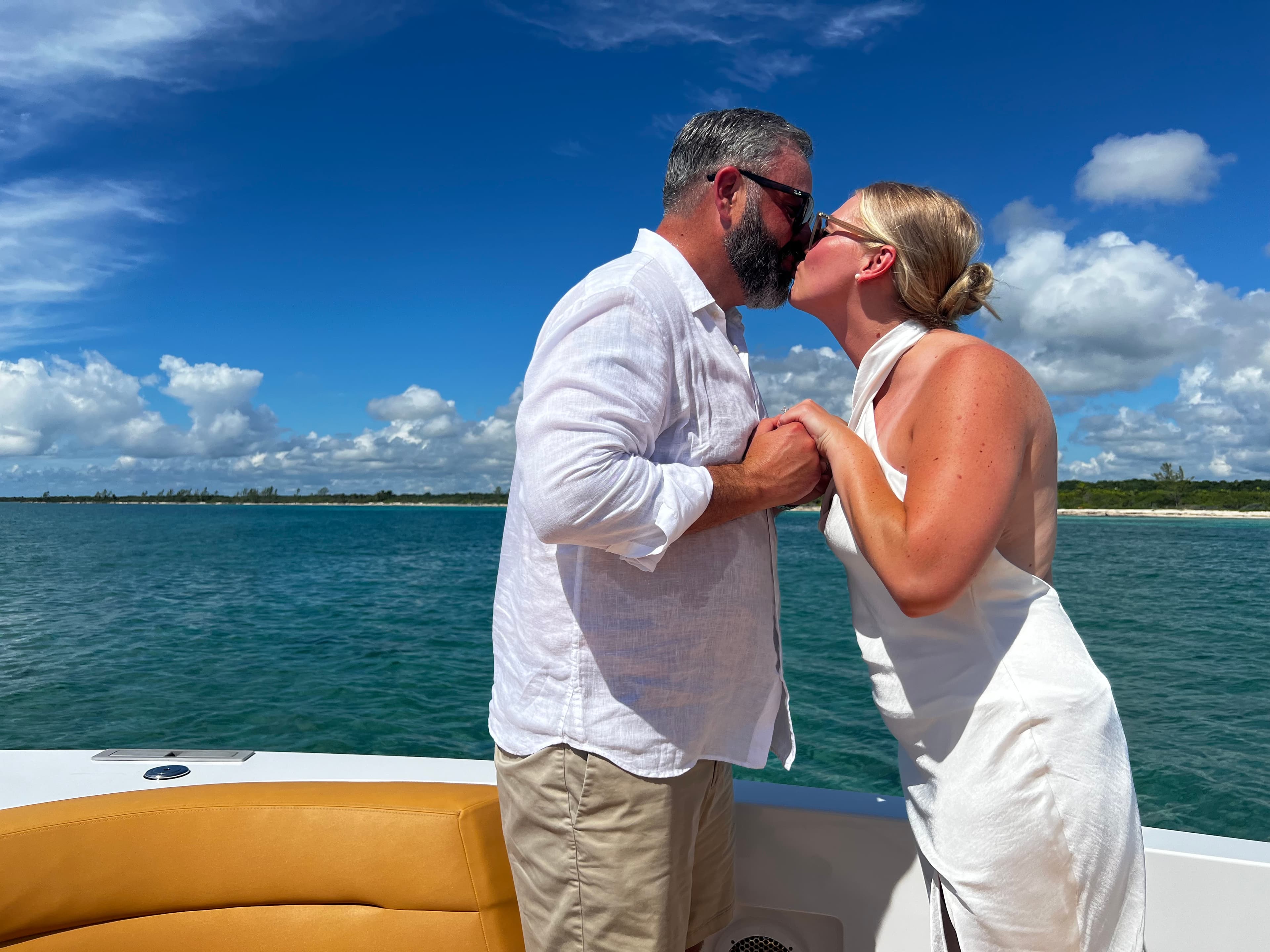 Advisor and partner embracing while holding hands on a boat on a sunny day