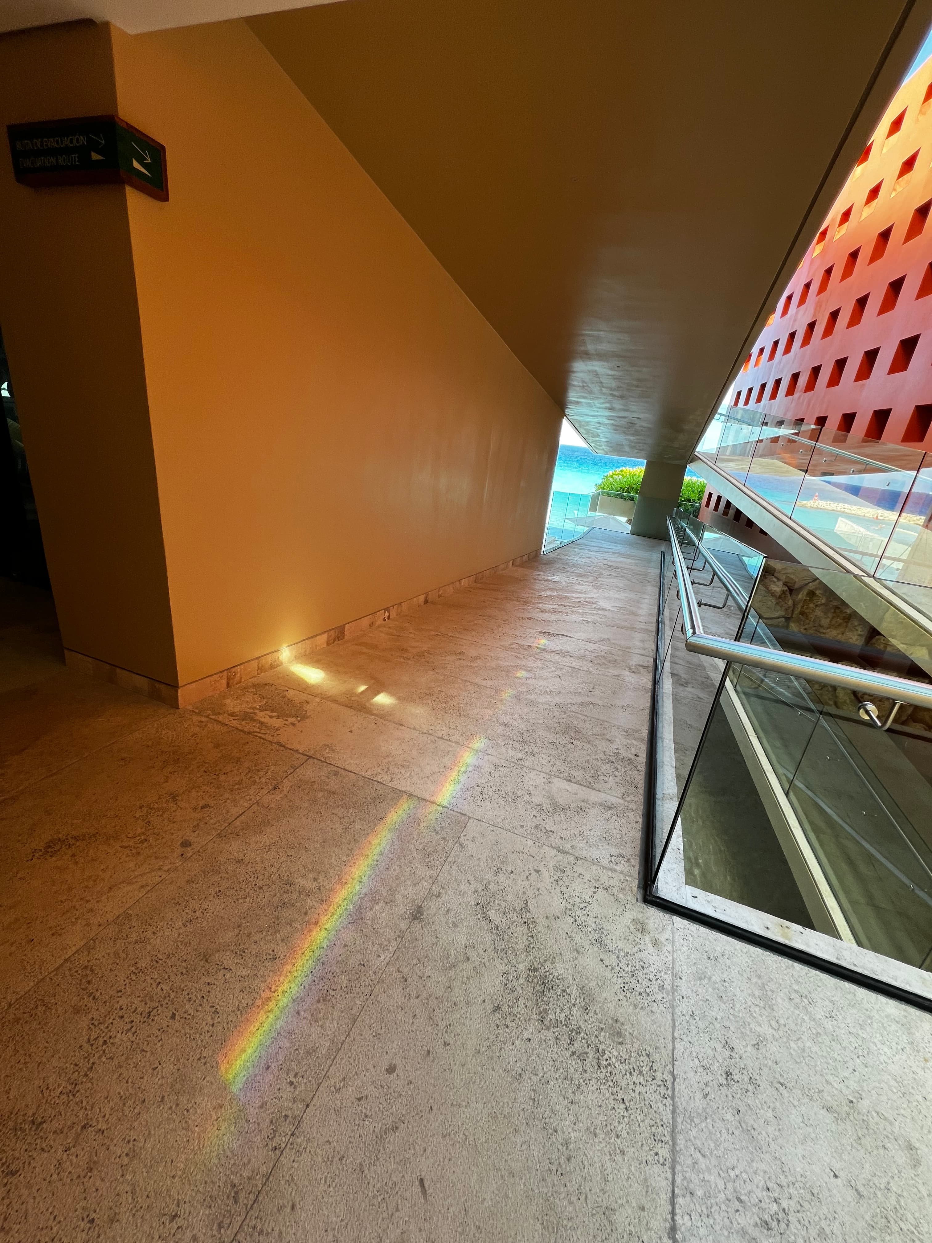 View of an outdoor hallway with rainbow light reflecting on the ground