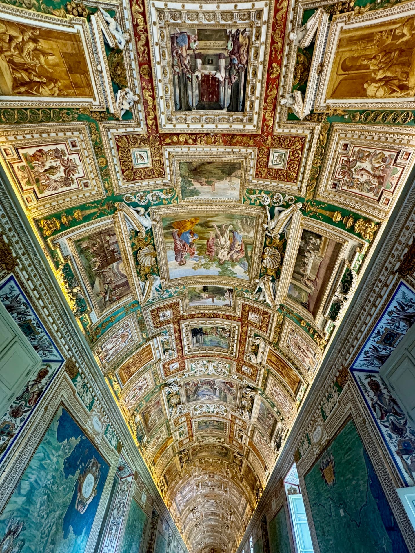View of an ornately designed ceiling with various paintings in a grand hall