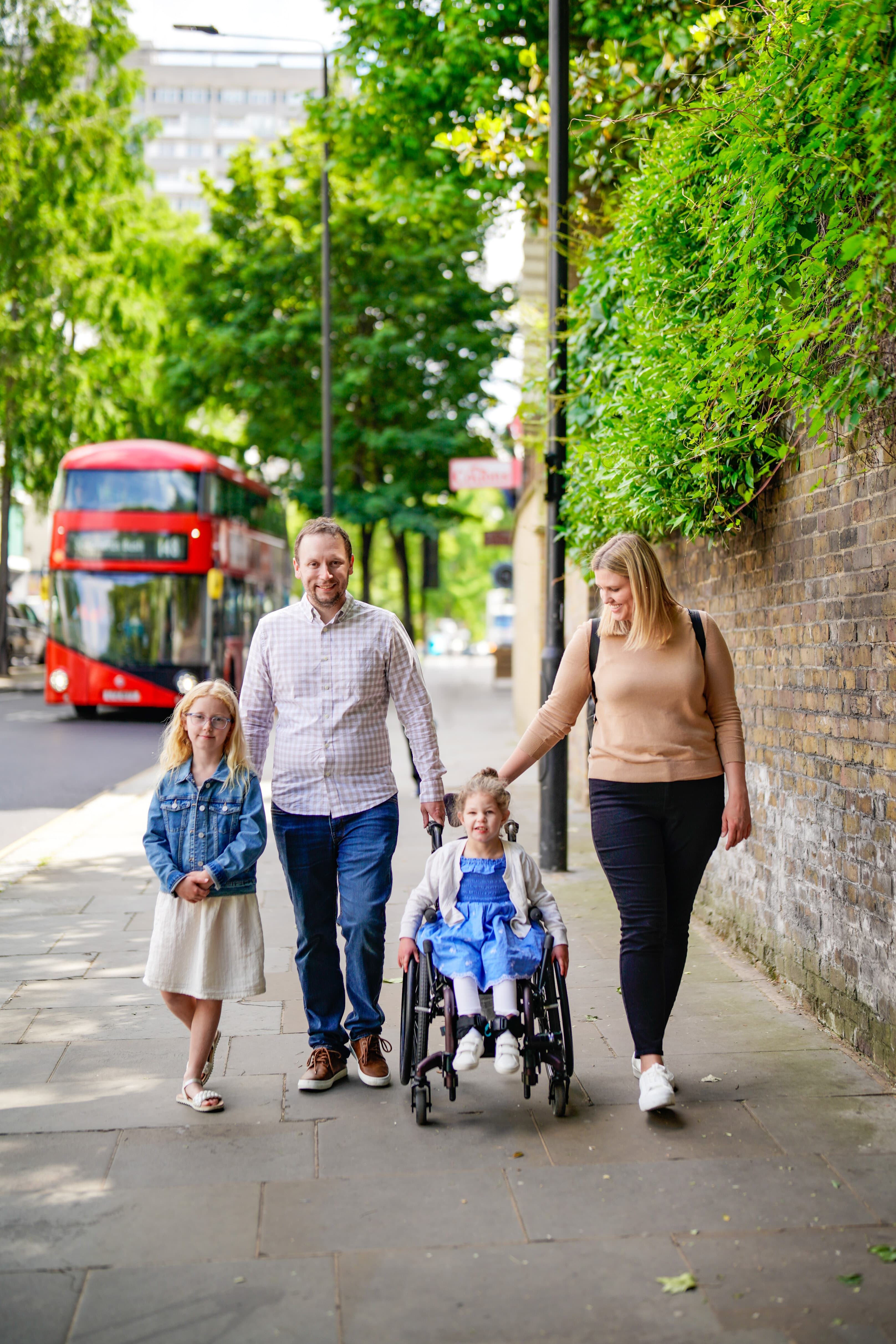 Advisor and family walking down the sidewalk in England on a sunny day