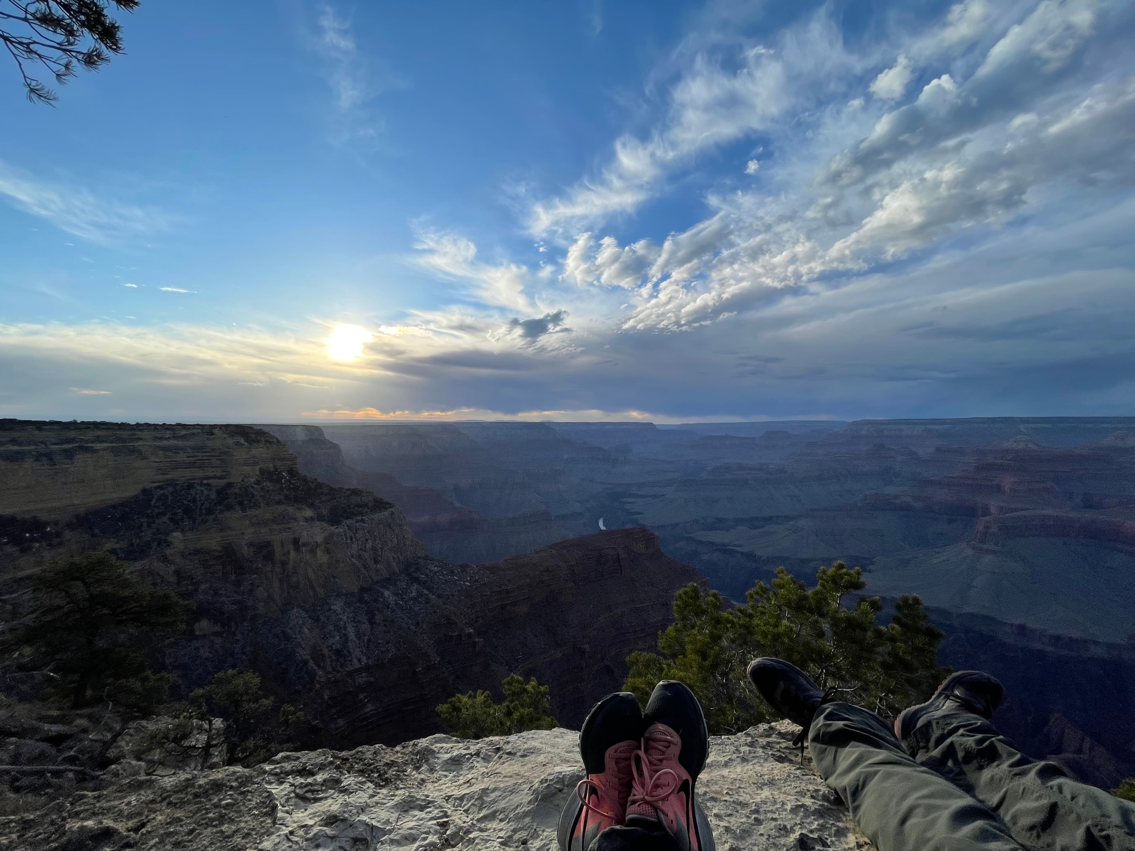 Advisor’s feet on a rock overlooking a beautiful valley at sundown