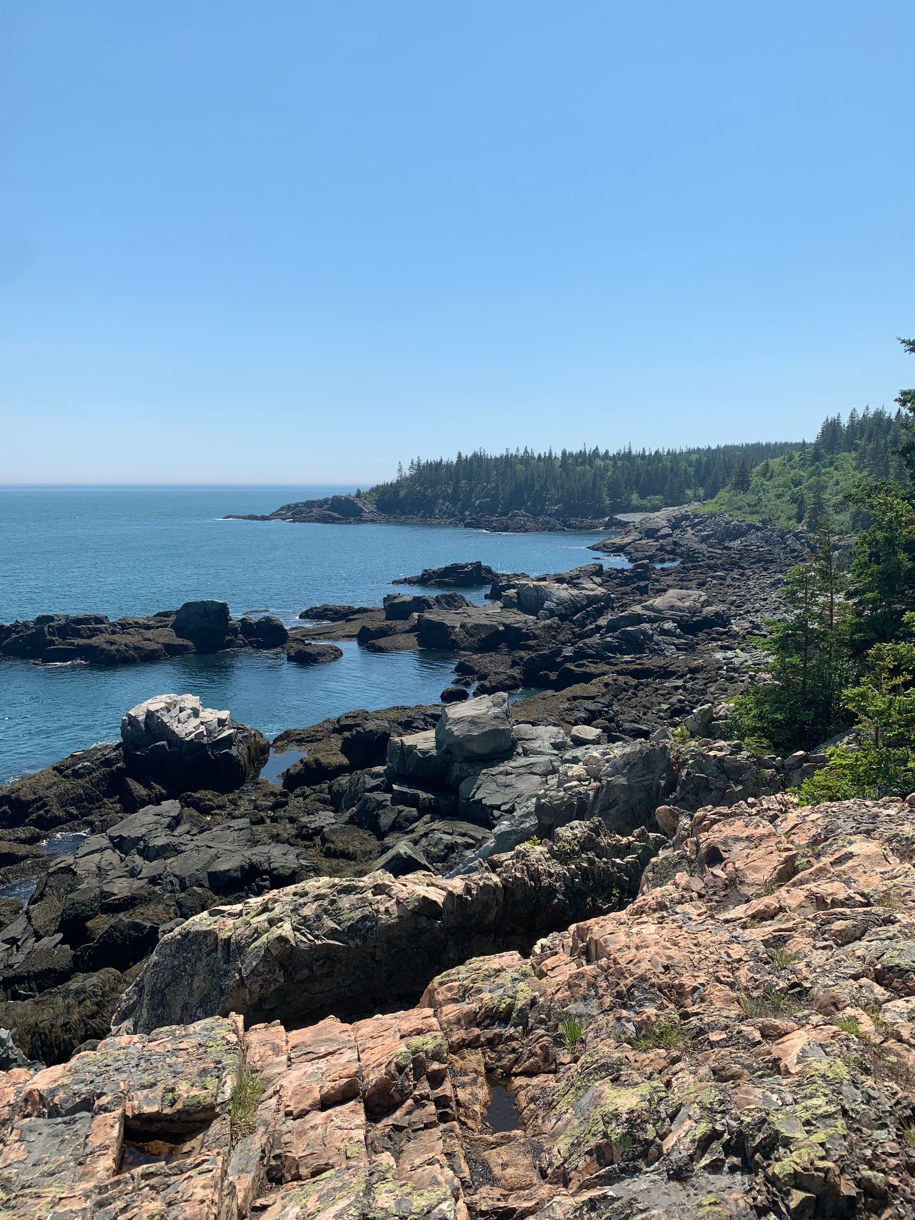 View of a rocky coastal area and calm ocean water on a clear day