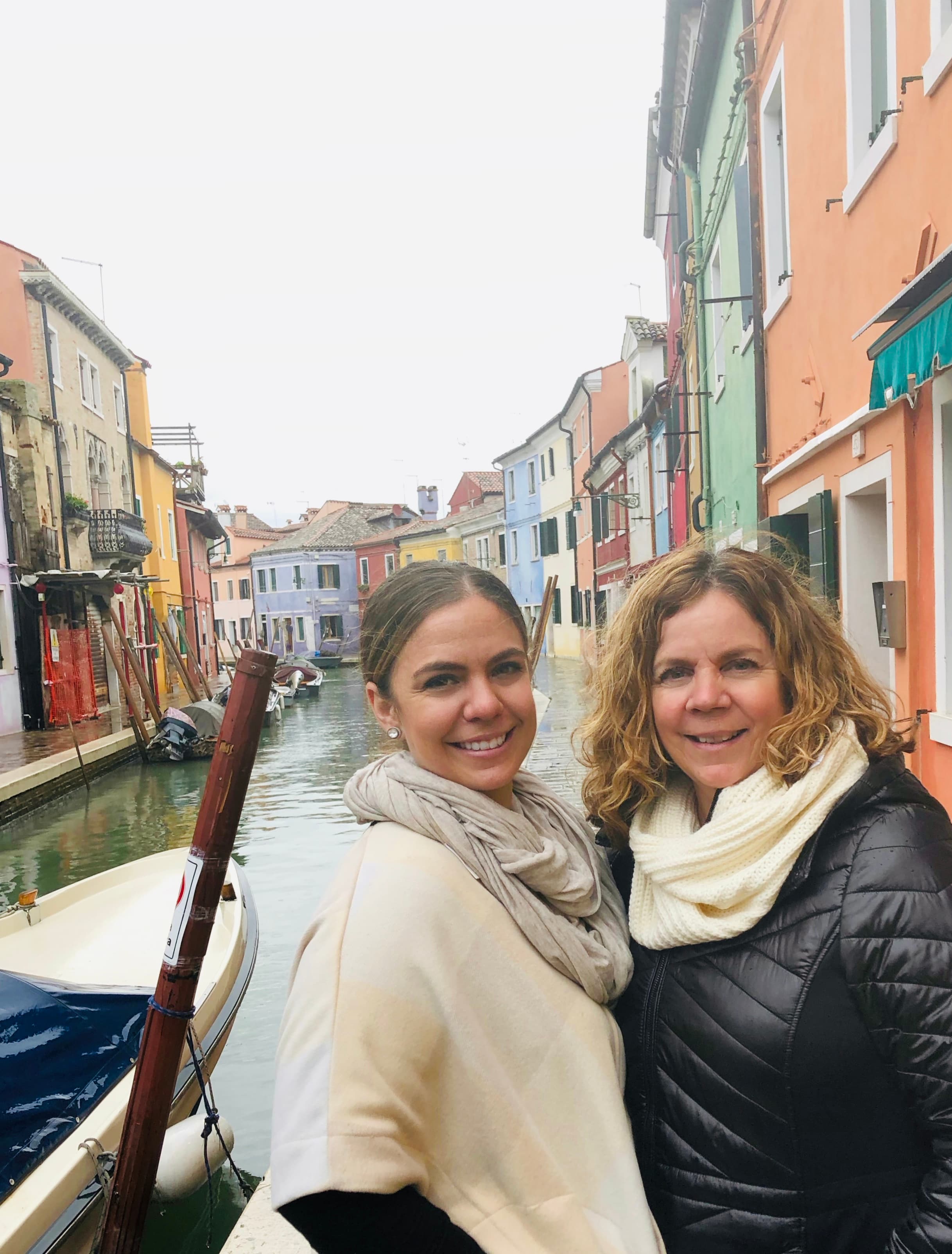 Advisor and her mother smiling by a canal in Venice on a cloudy day