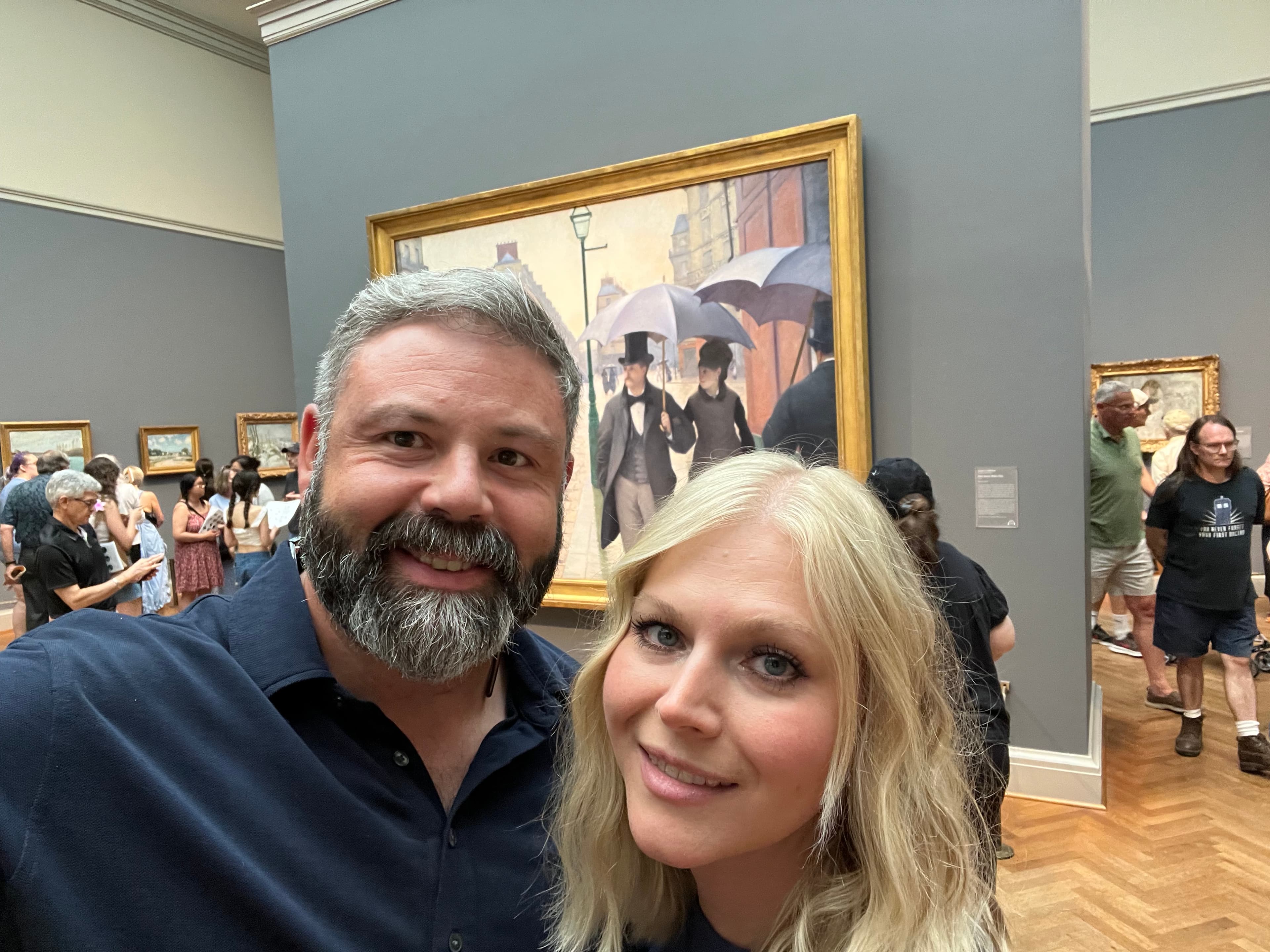 Advisor and partner smiling for a selfie inside a museum