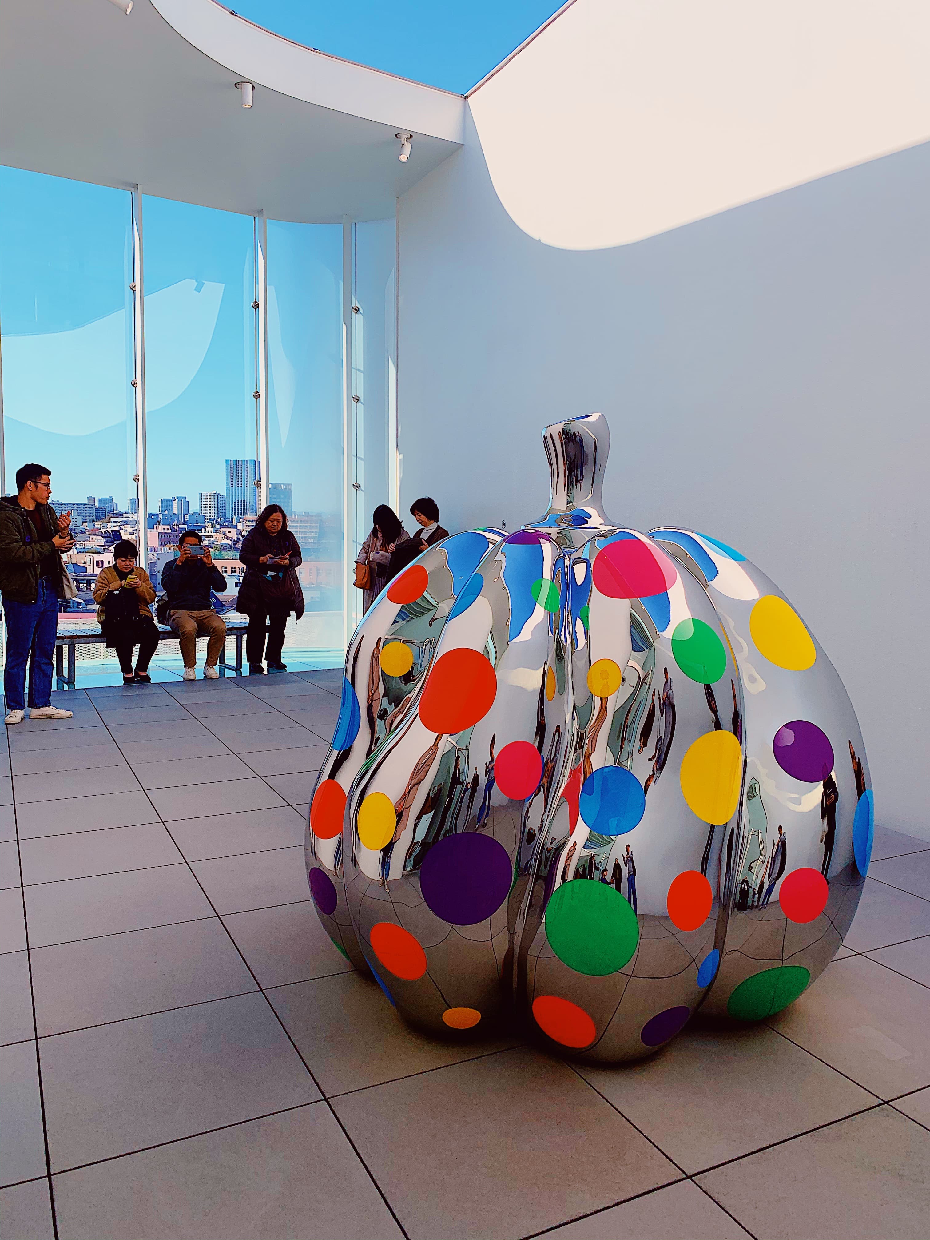 A colorful and metallic sculpture in a museum