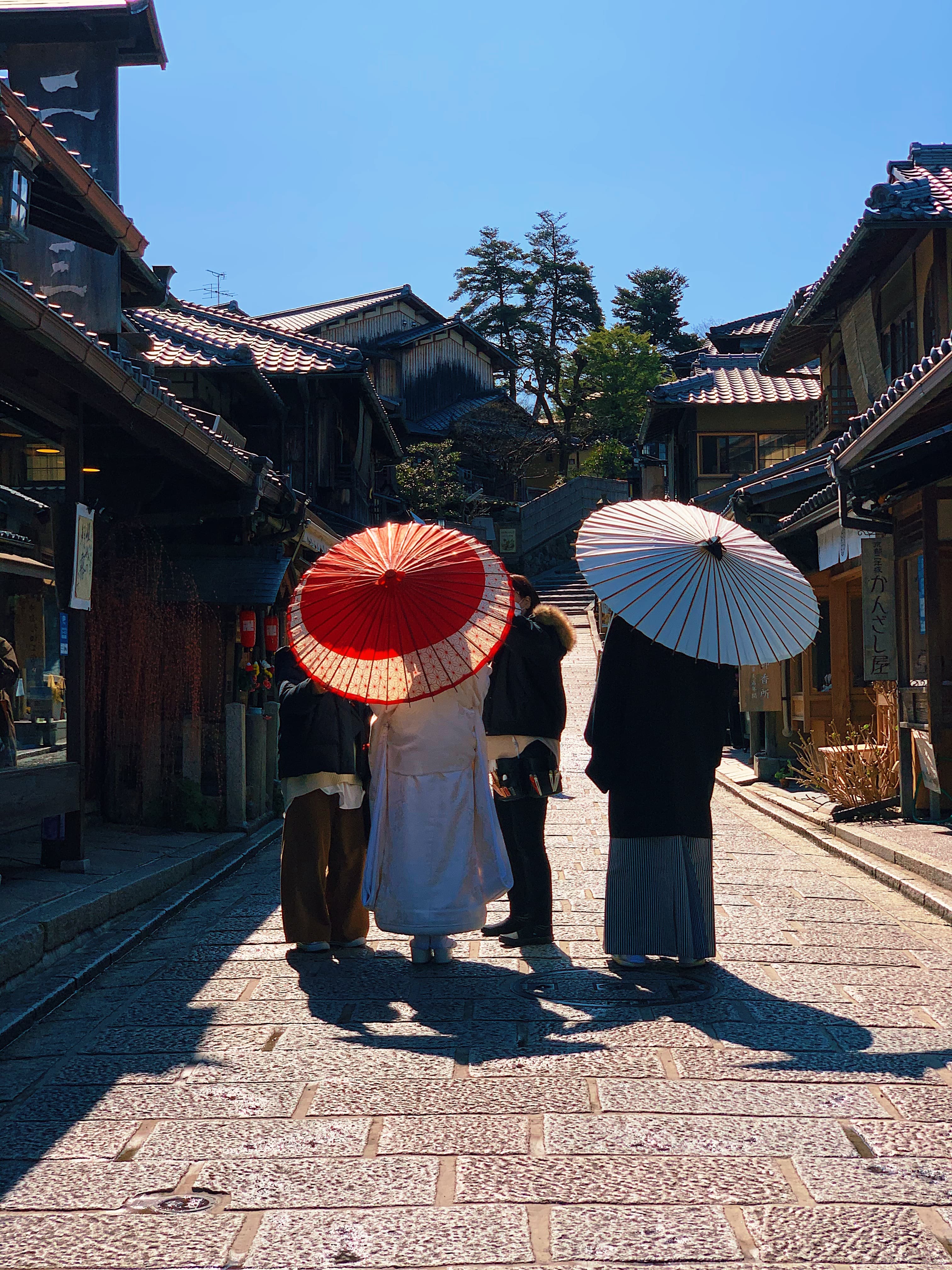 People walking down the street with traditional Japanese umbrellas