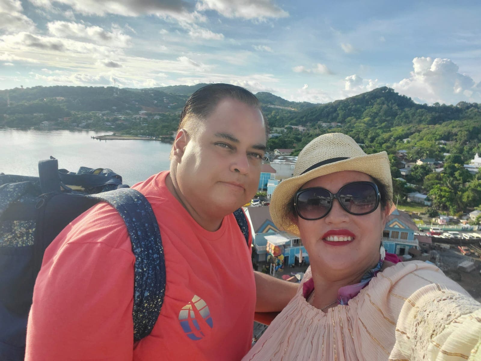 Advisor and partner taking a selfie at a viewpoint overlooking a sunny coastline