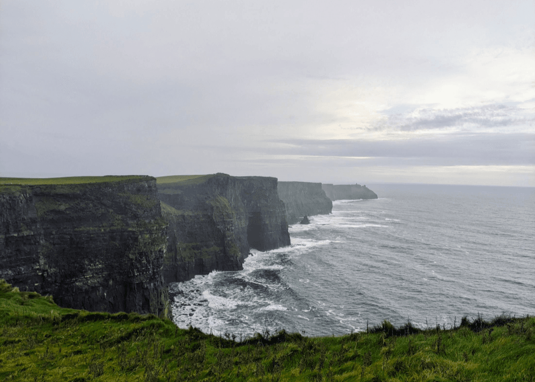 View of beautiful dramatic cliffs stretching down a rainy coastline as far as the eye can see