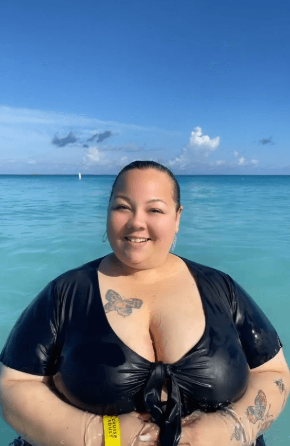 Advisor smiling on the beach with bright blue water and clear skies in the background