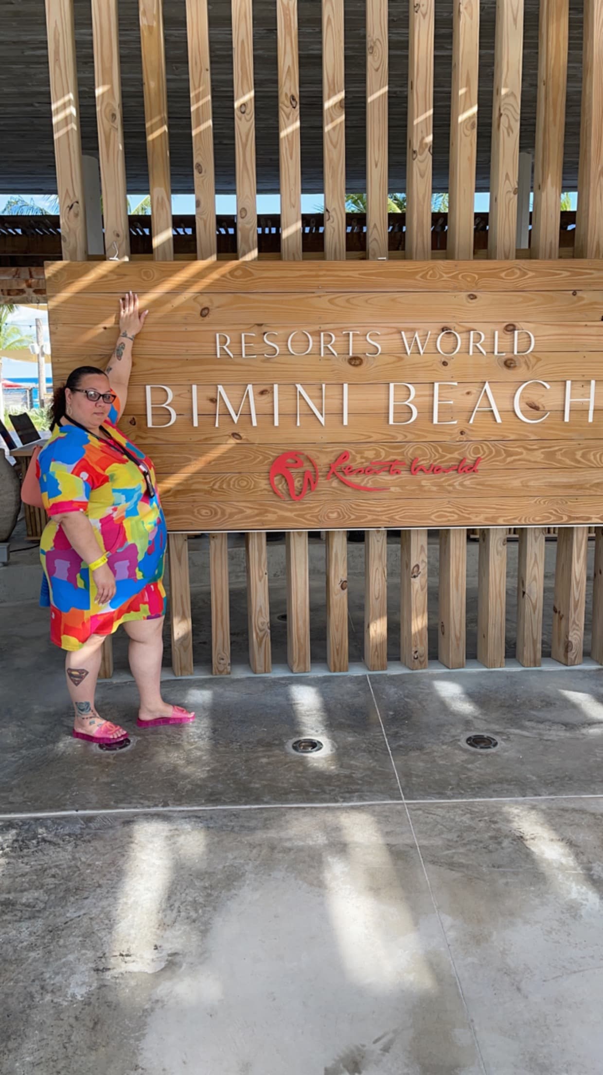 Advisor posing beside a wooden sign for Bimini Beach