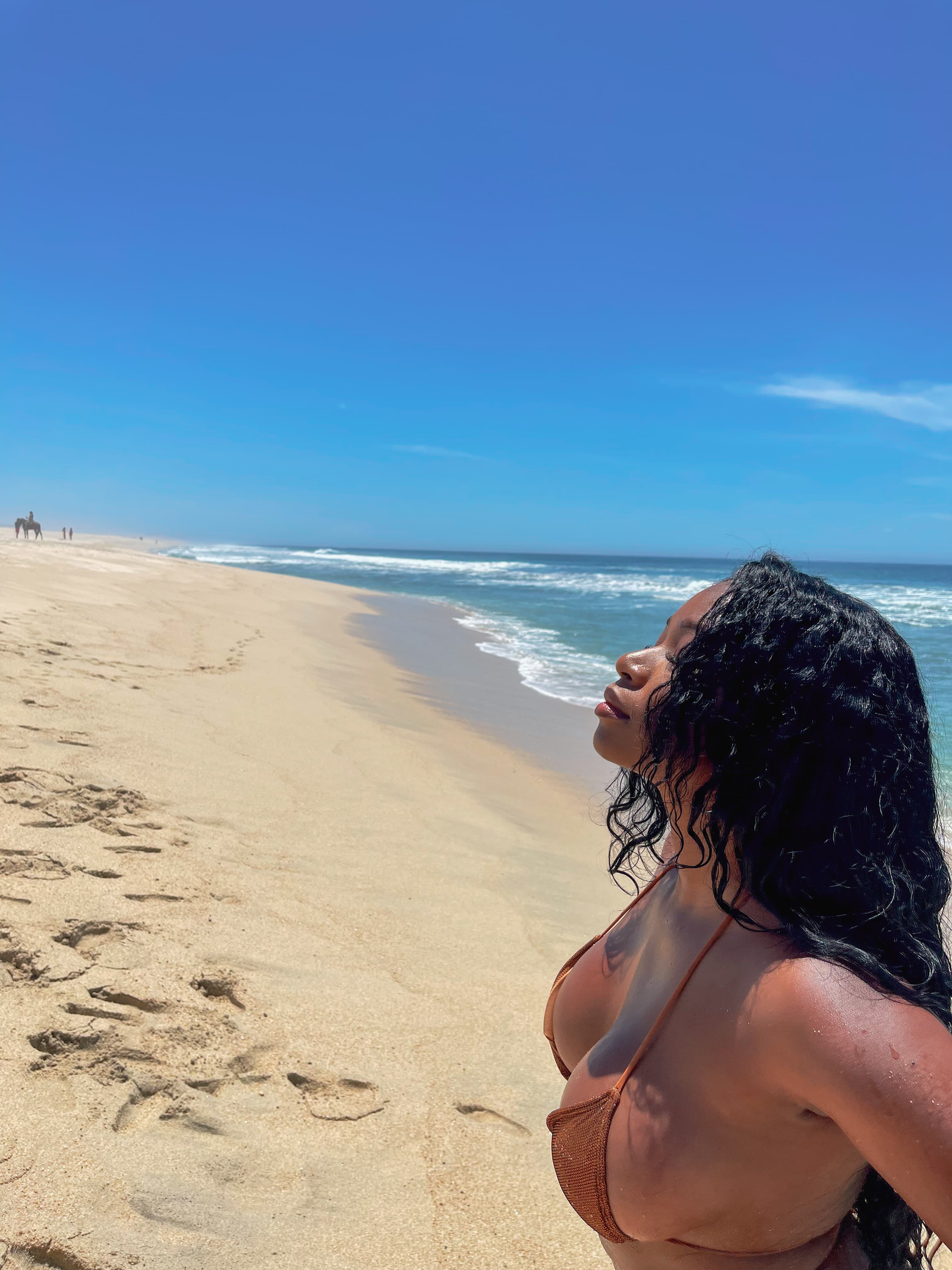 Advisor looking towards the sky on a beautiful sunny beach with calm waves
