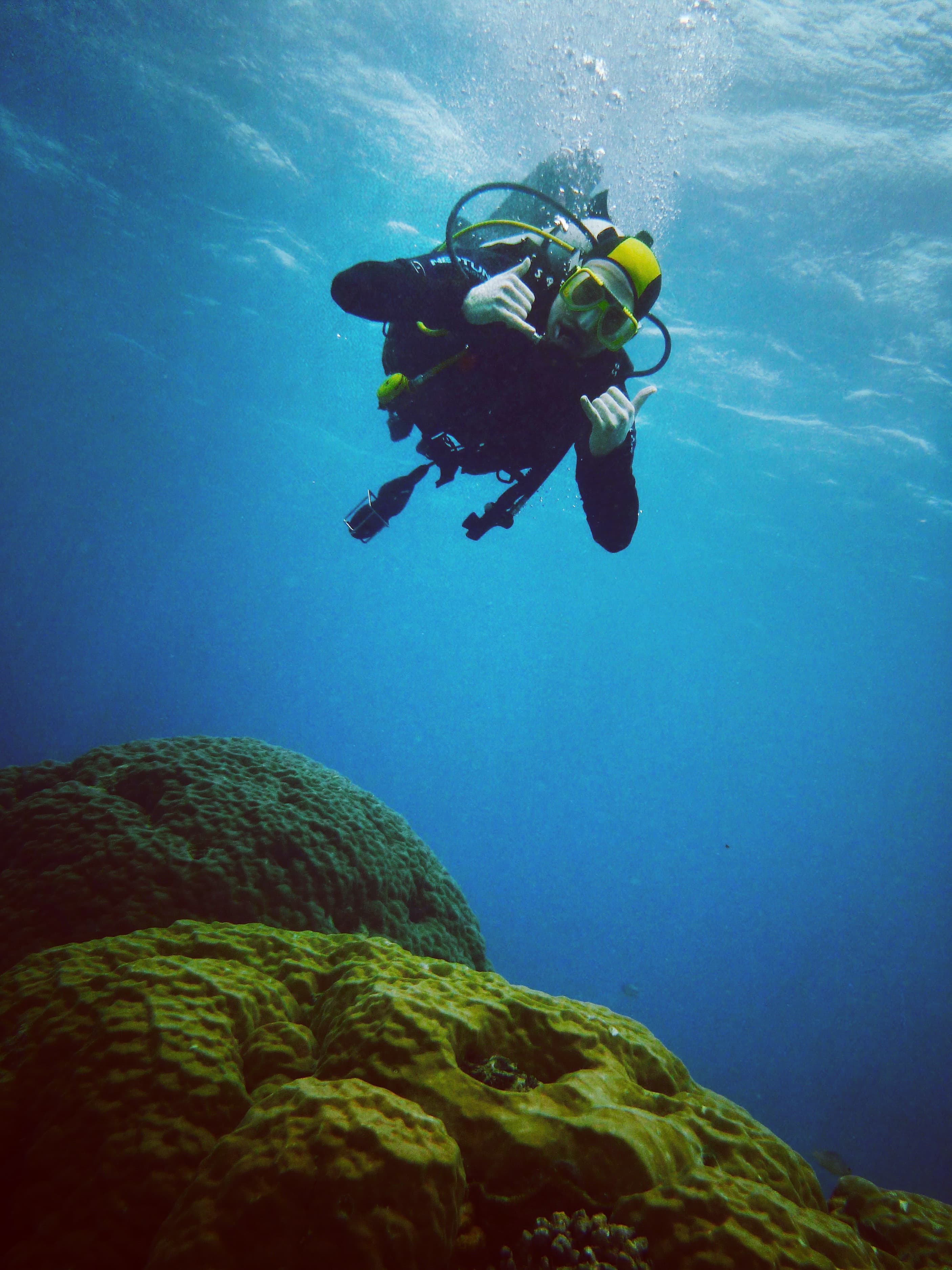 Advisor seen underwater in scuba gear with sunlight streaming through the ocean’s surface