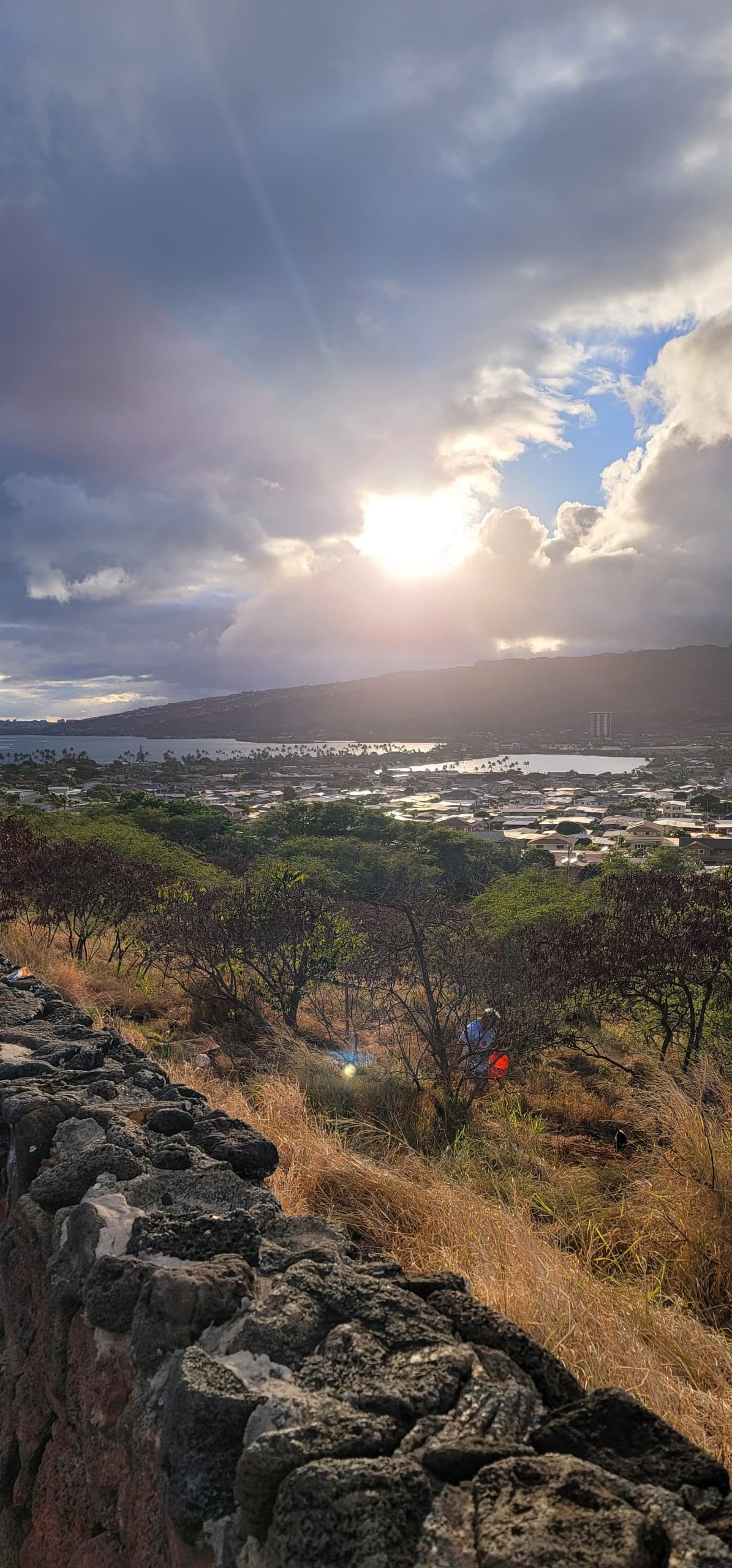 View of the sun shining through the clouds over a beautiful lake and mountain landscape