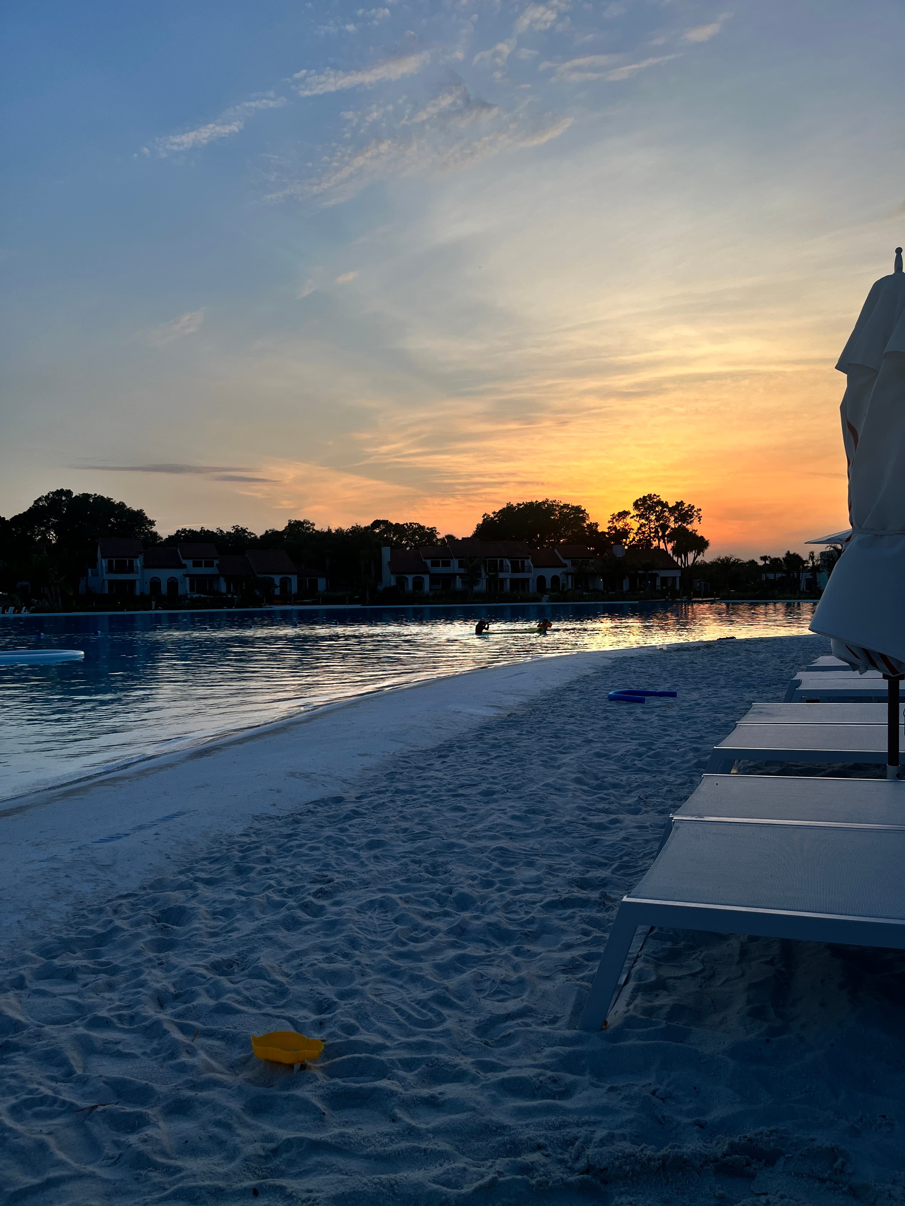 View of sunset over treetops and an empty beach