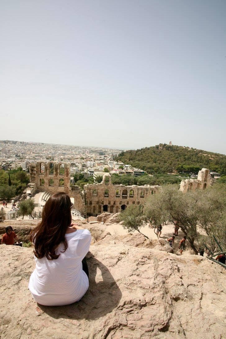 Michelle posing on top of a mountain during the daytime while overlooking the city. 