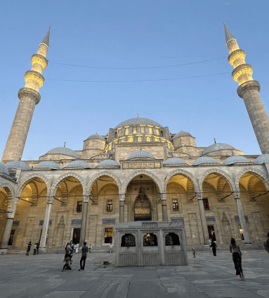 View of a beautiful golden mosque with two minarets on a clear evening in Türkiye
