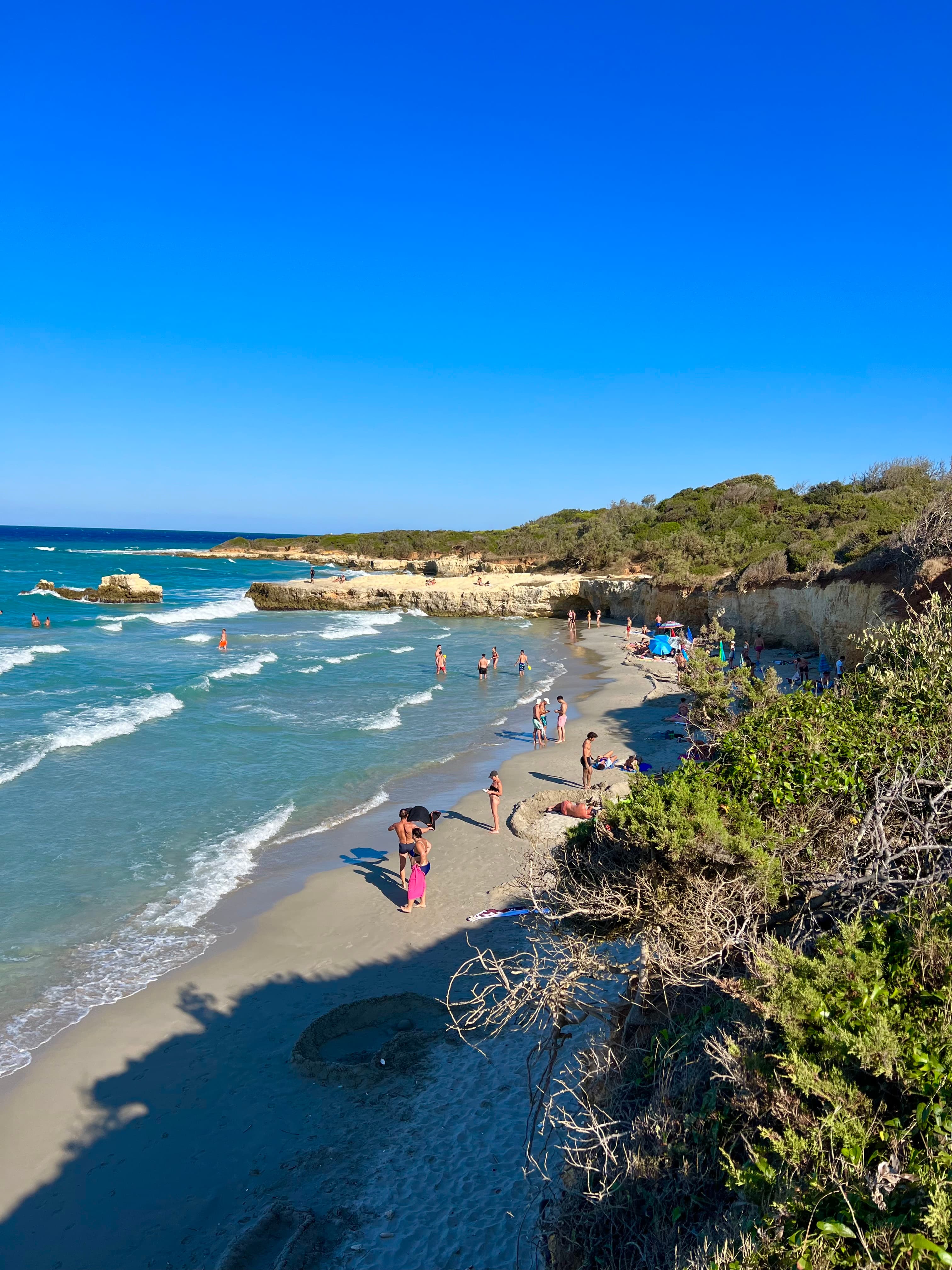 View of a beautiful beach under bright blue skies with waves breaking just off shore 