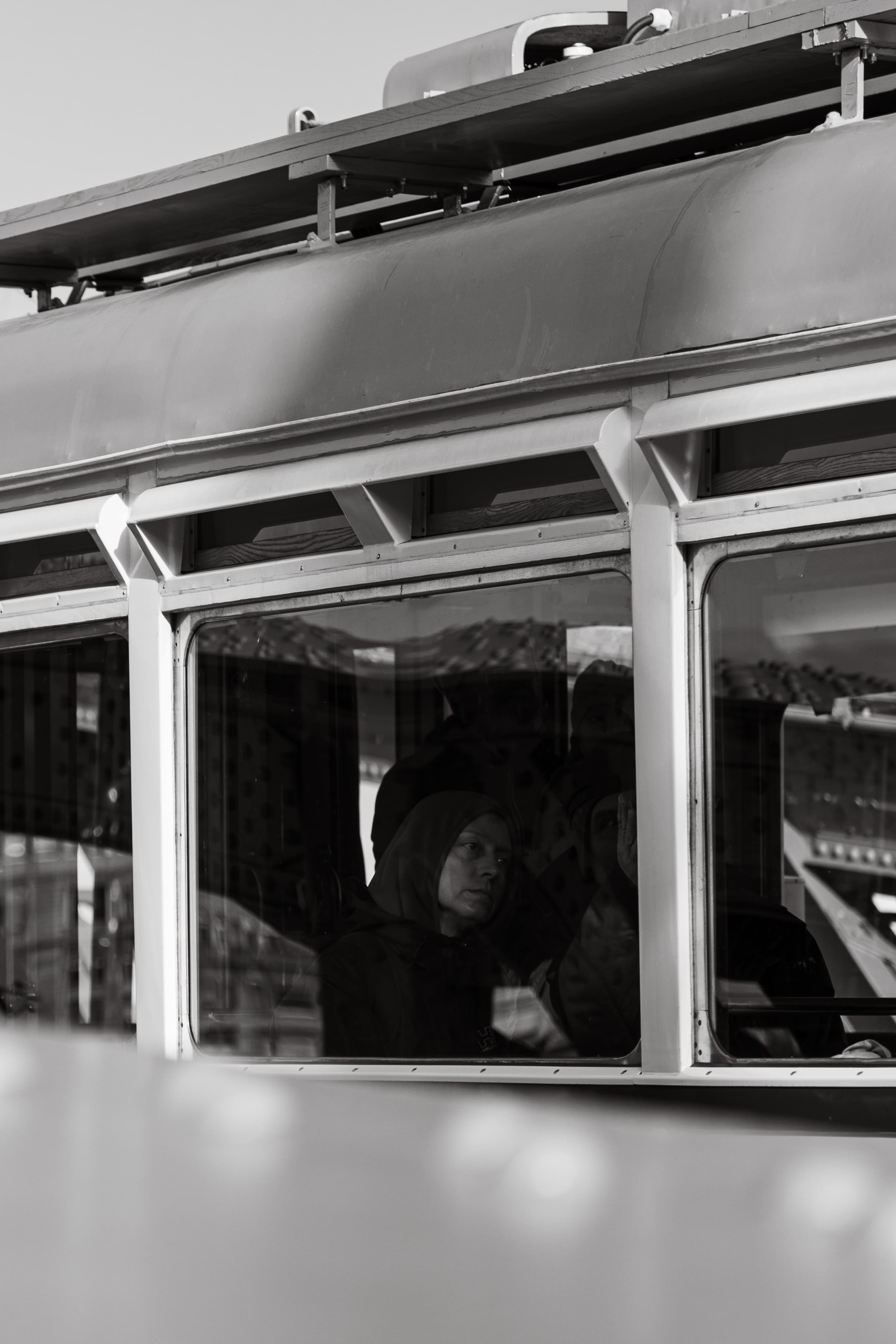Black and white photo of a woman on a train.