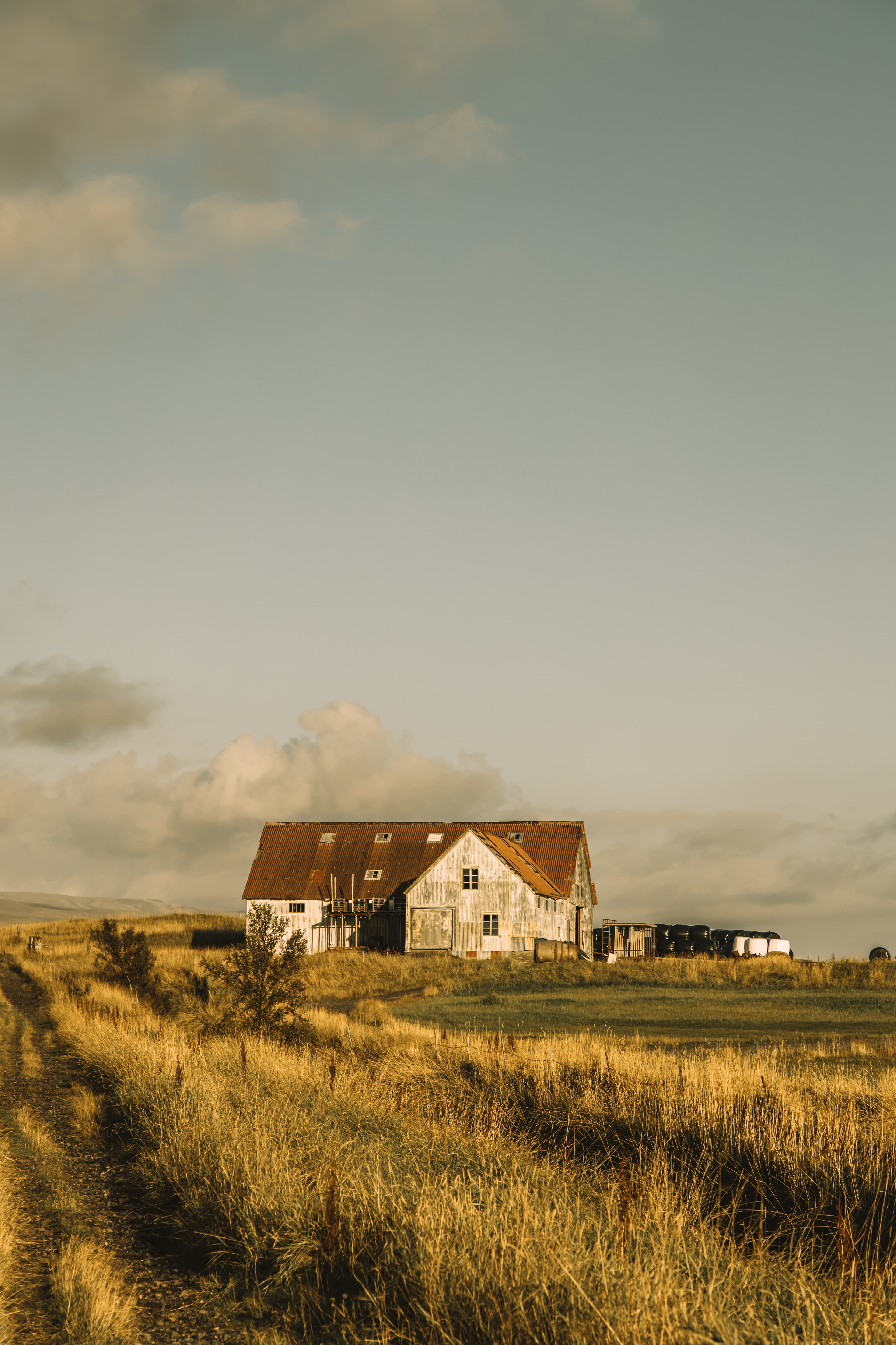Scenic picture of a house from a distance from a field during the daytime.