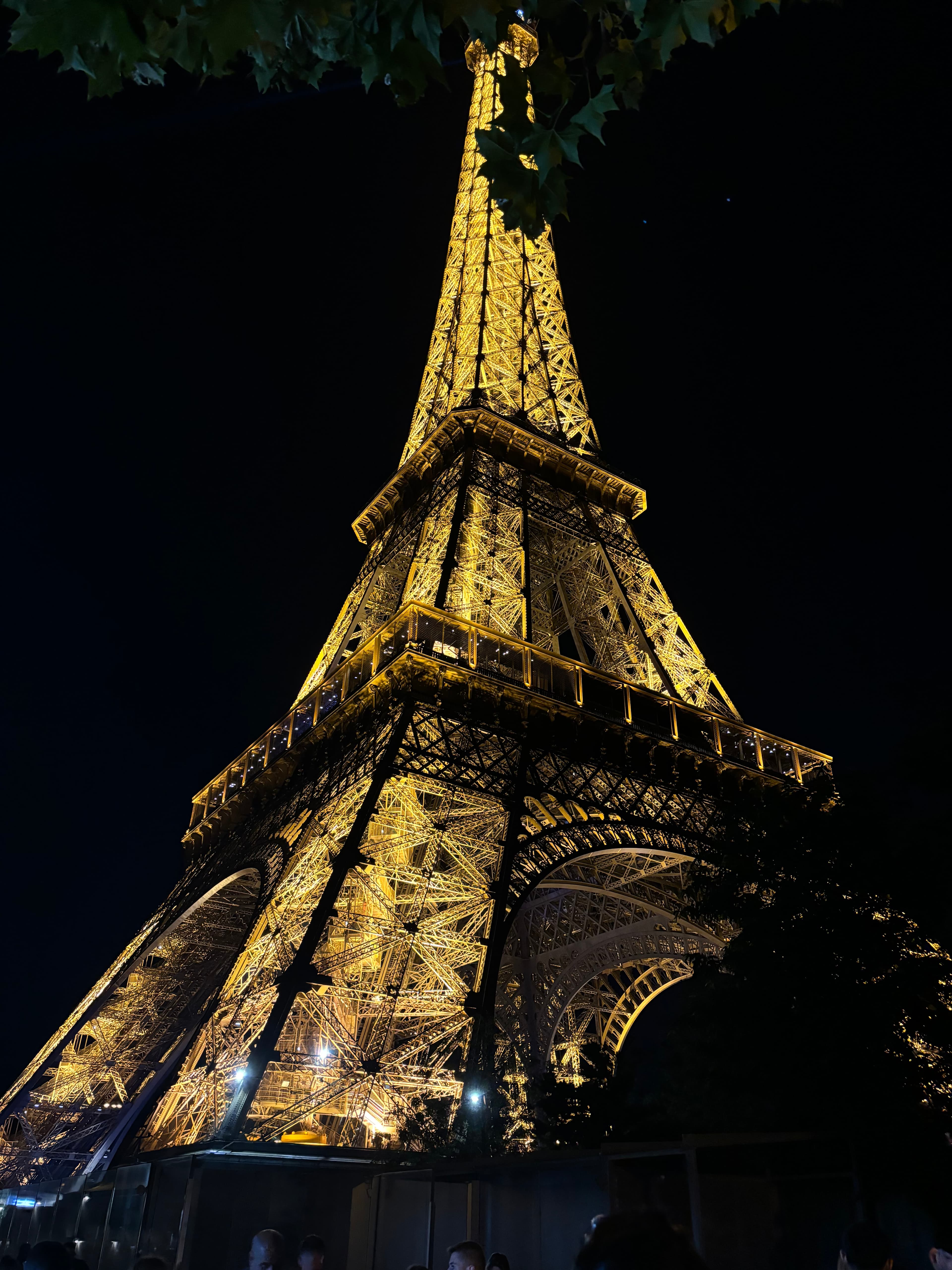 A view of the Eiffel Tower lit up at night. 