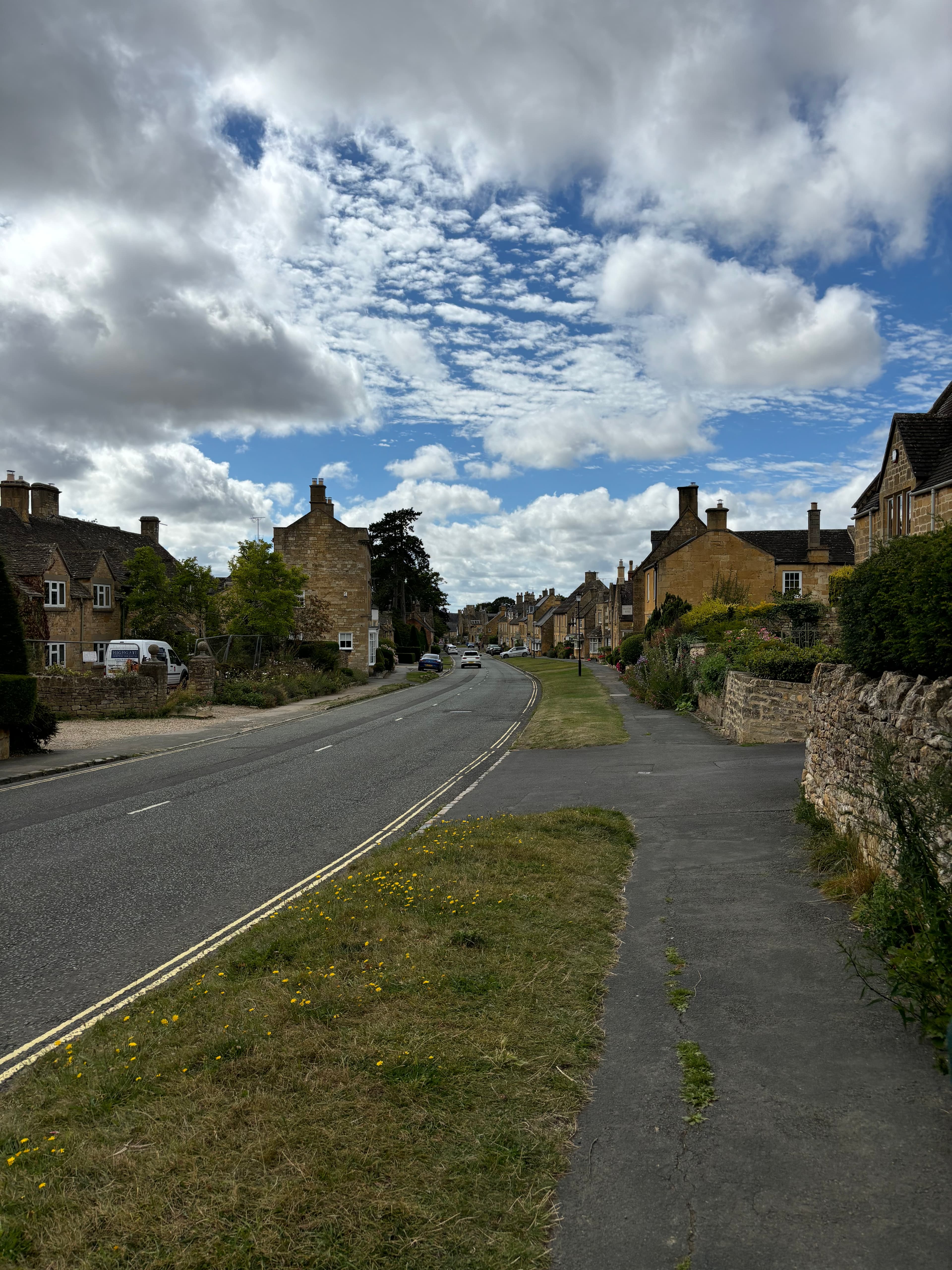 A view of a quaint town with two lane road during the daytime. 
