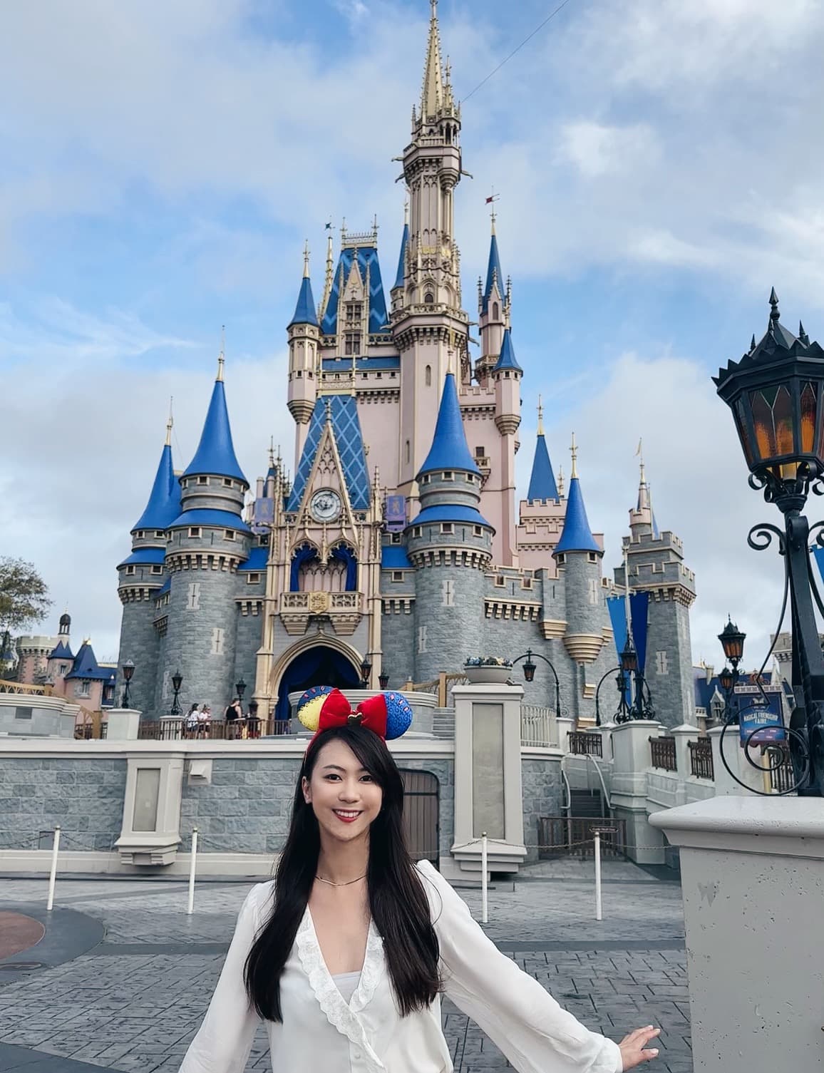 Advisor posing for an image outside of Disneyland on a sunny day.