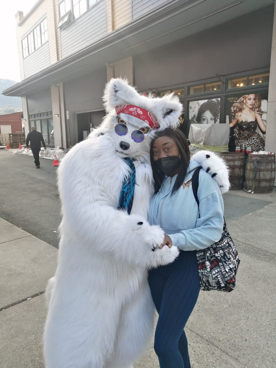 Advisor posing outdoors beside a person in a large white furry animal costume