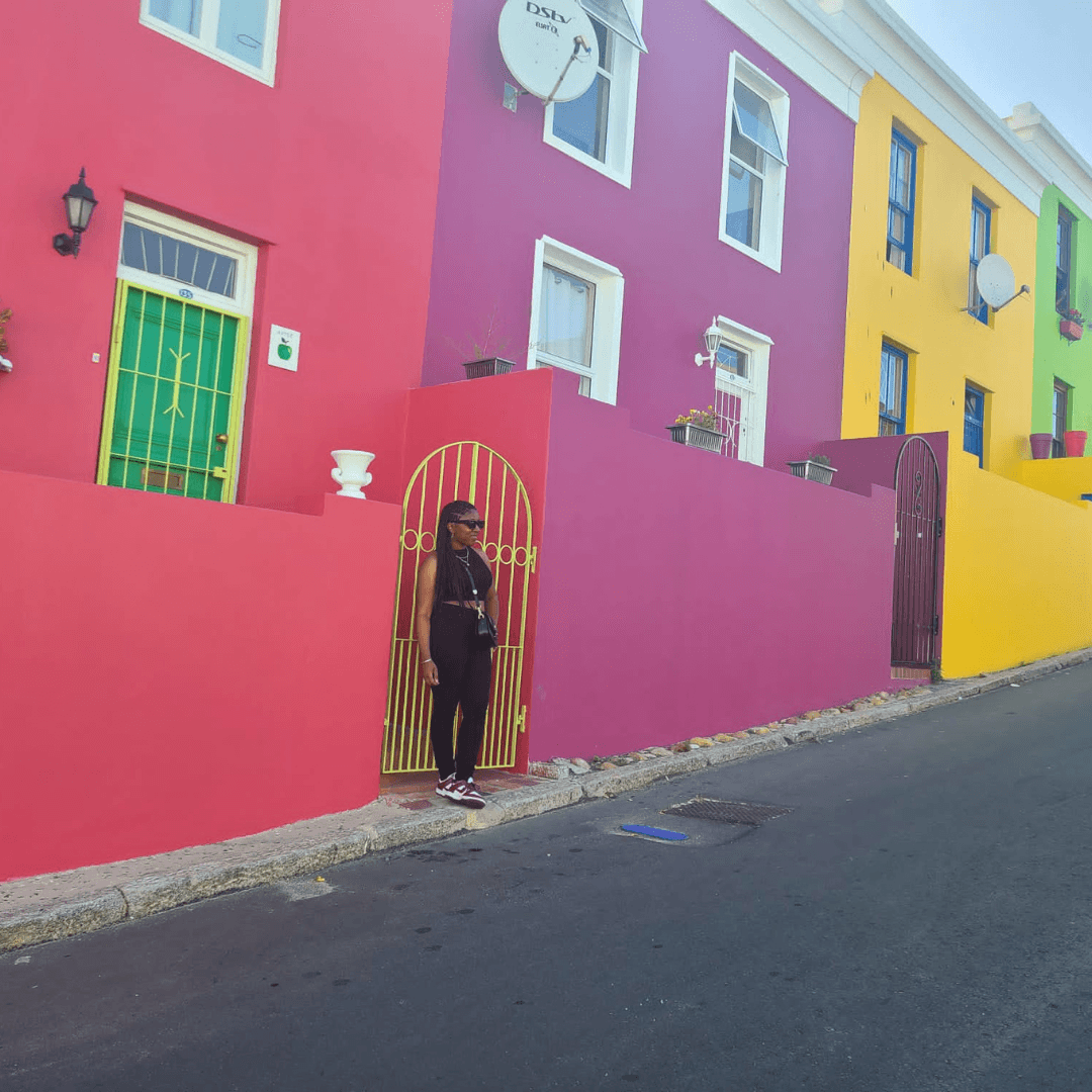 Standing in front of colorful buildings.