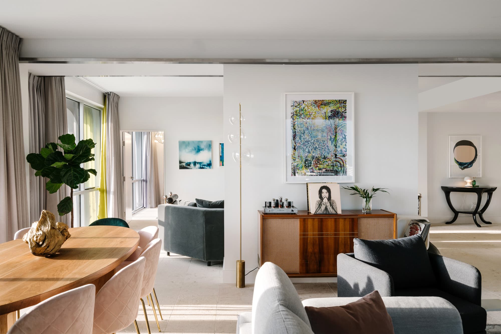 a modern, stylish hotel living room with a pale round wooden table