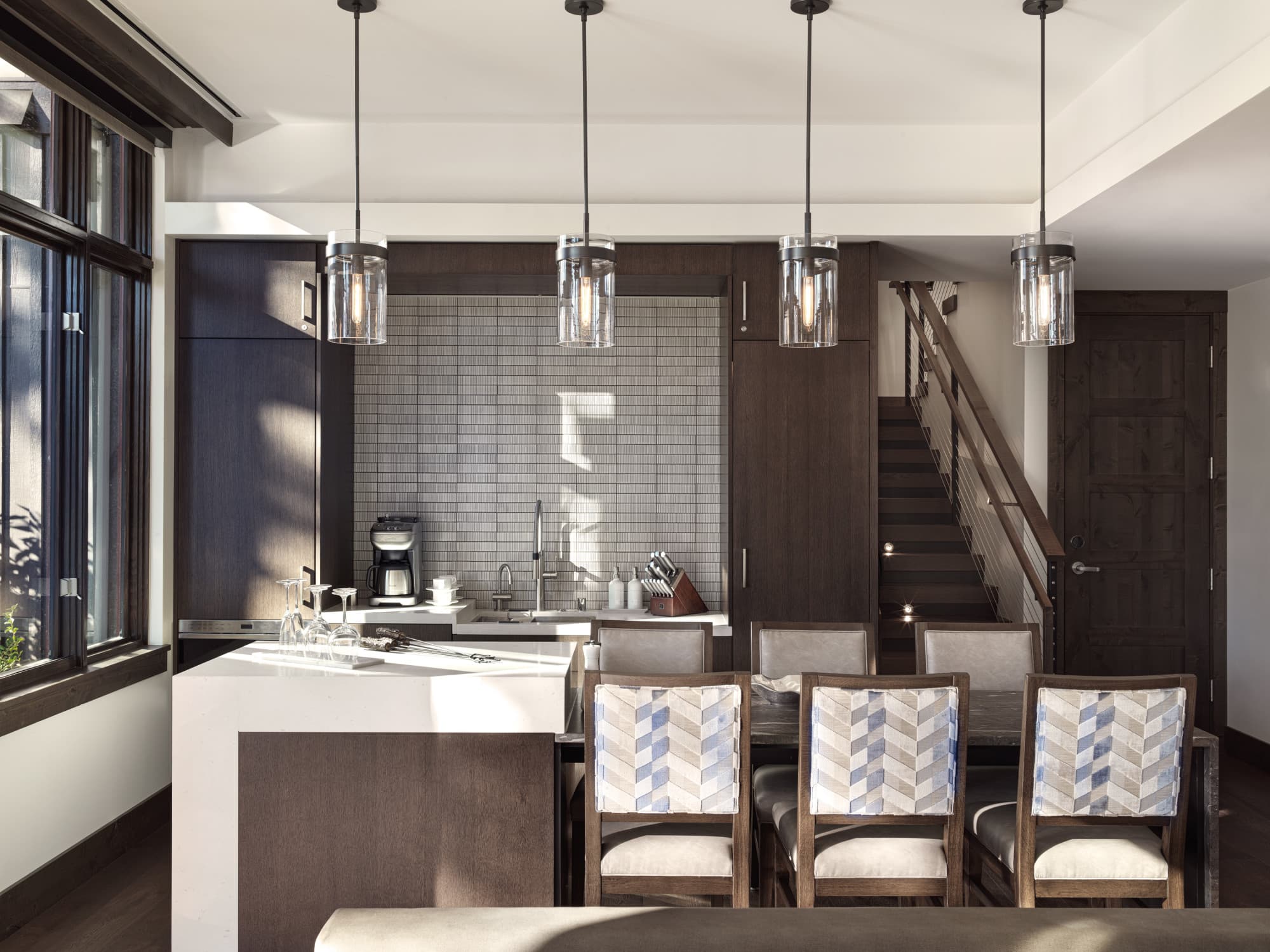 a modern kitchen with hanging glass lights