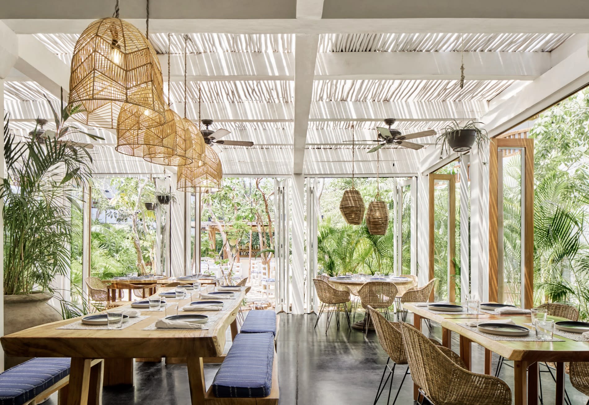 light-filled dining area with hanging basket lights and wood tables