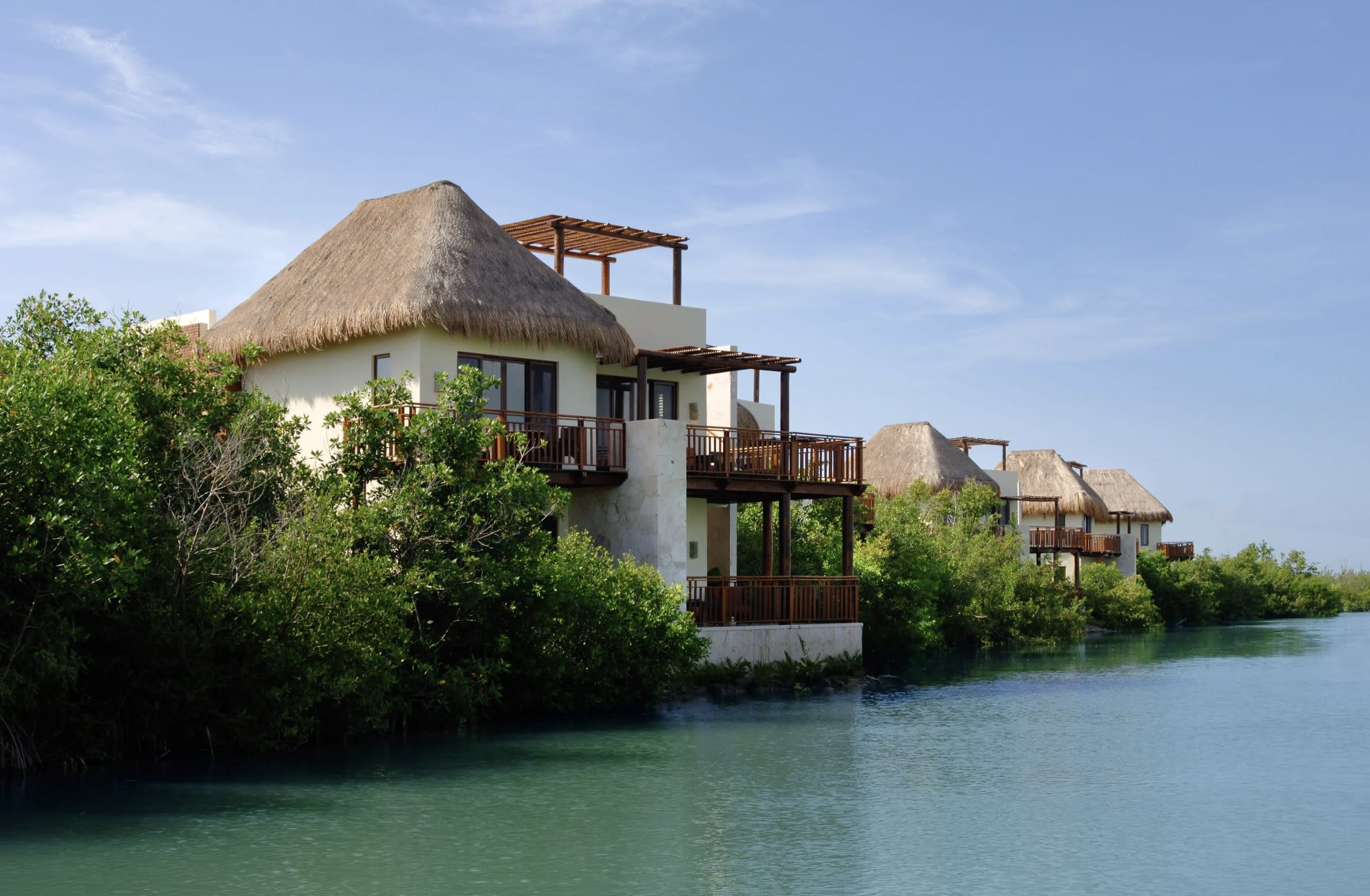 waterfront home with thatched room and greenery