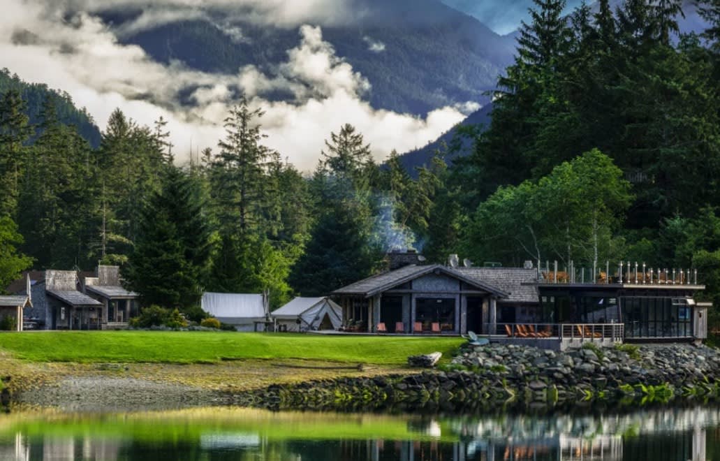 lakeside lodge with the mountains and forest behind