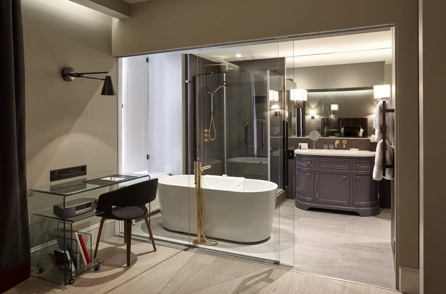 fancy bathroom with a soaking tub and gray vanity