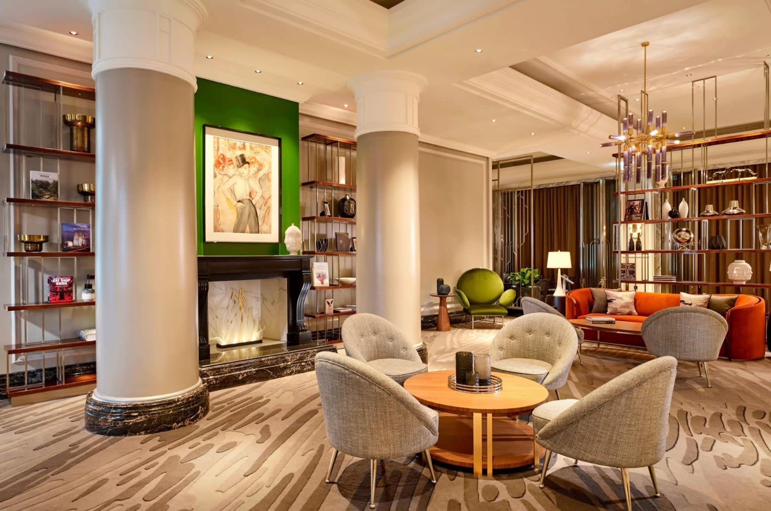 modern room with round columns, a fireplace and seating areas done in tan and orange